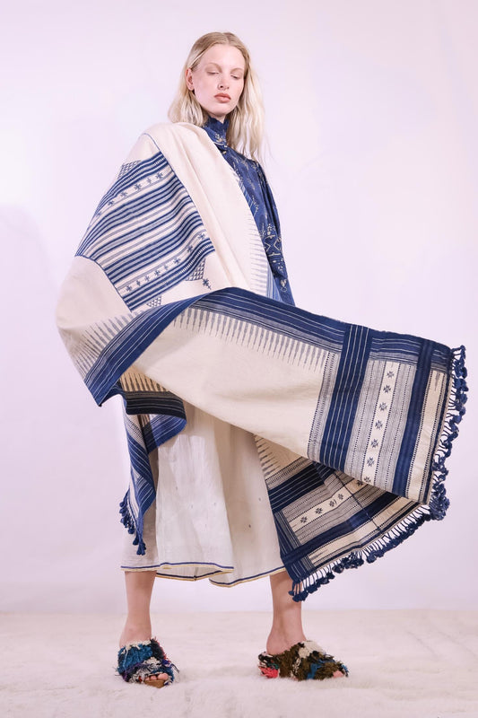 Handwoven kala cotton throw with embroidered panels by Shamji Vankar Vishram Valji, crafted in Bhujodi, India. Made from handspun yarn for a rich, textured feel. A heritage piece curated by House of Woven Stories, blending tradition, sustainability, and artisan craftsmanship. Available at House of Woven Stories.