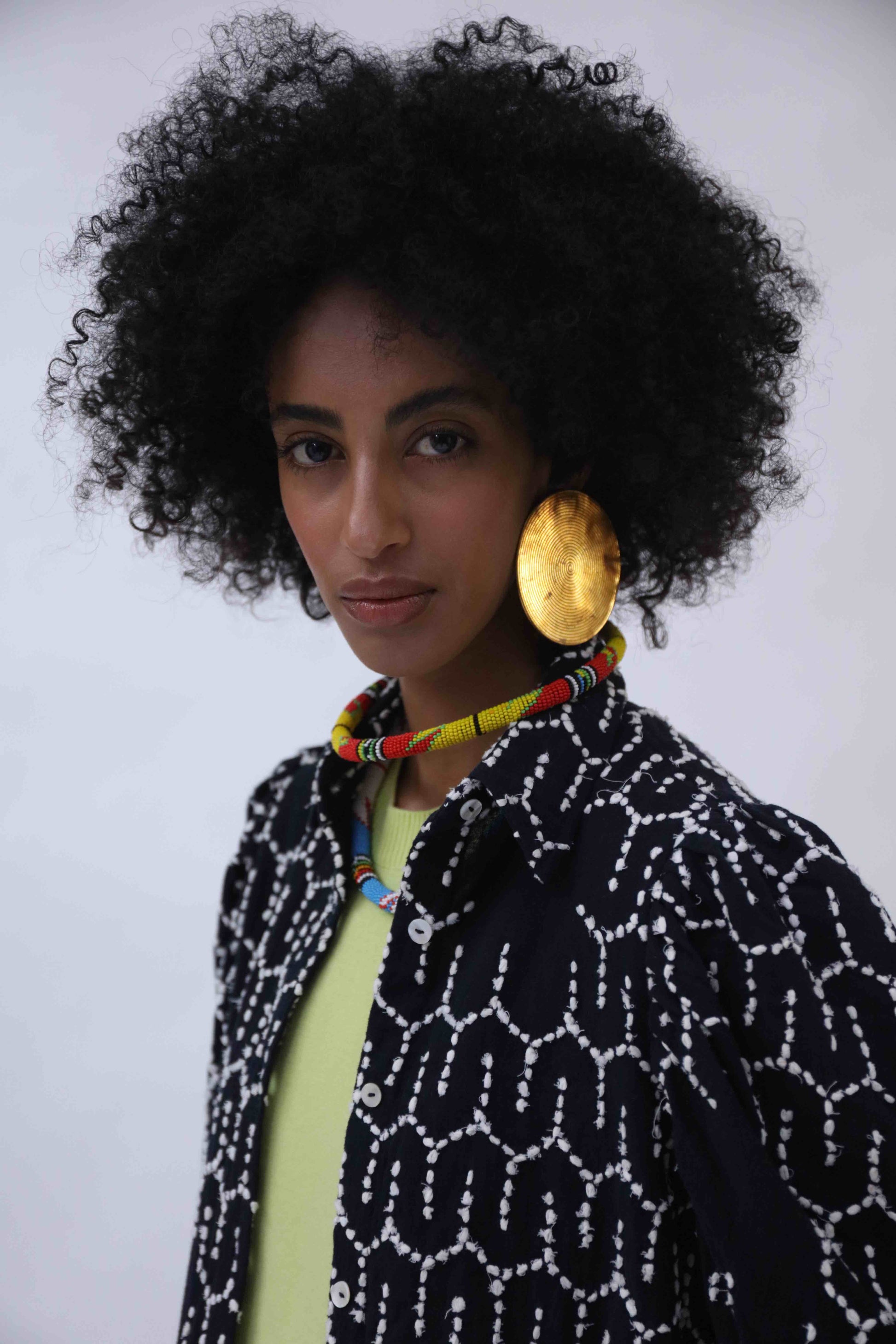 Structured puff-sleeve blouse with sharp collars and Paiwand’s signature upcycled embroidery on organic indigo-dyed cotton, handcrafted in India combining traditional craftsmanship with sustainable, modern fashion.