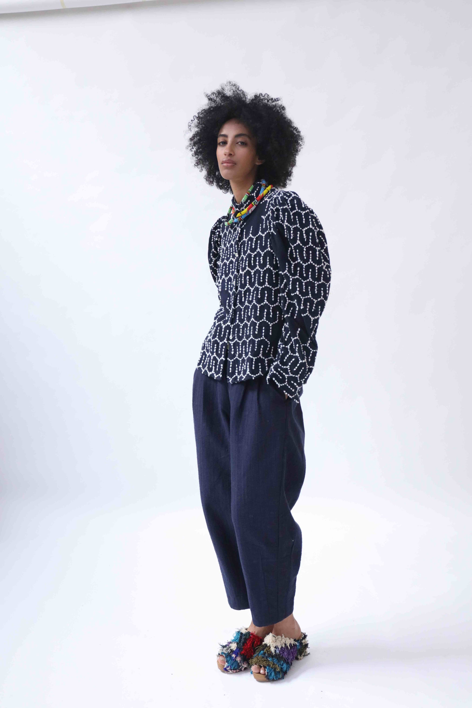 Structured puff-sleeve blouse with sharp collars and Paiwand’s signature upcycled embroidery on organic indigo-dyed cotton, handcrafted in India combining traditional craftsmanship with sustainable, modern fashion.