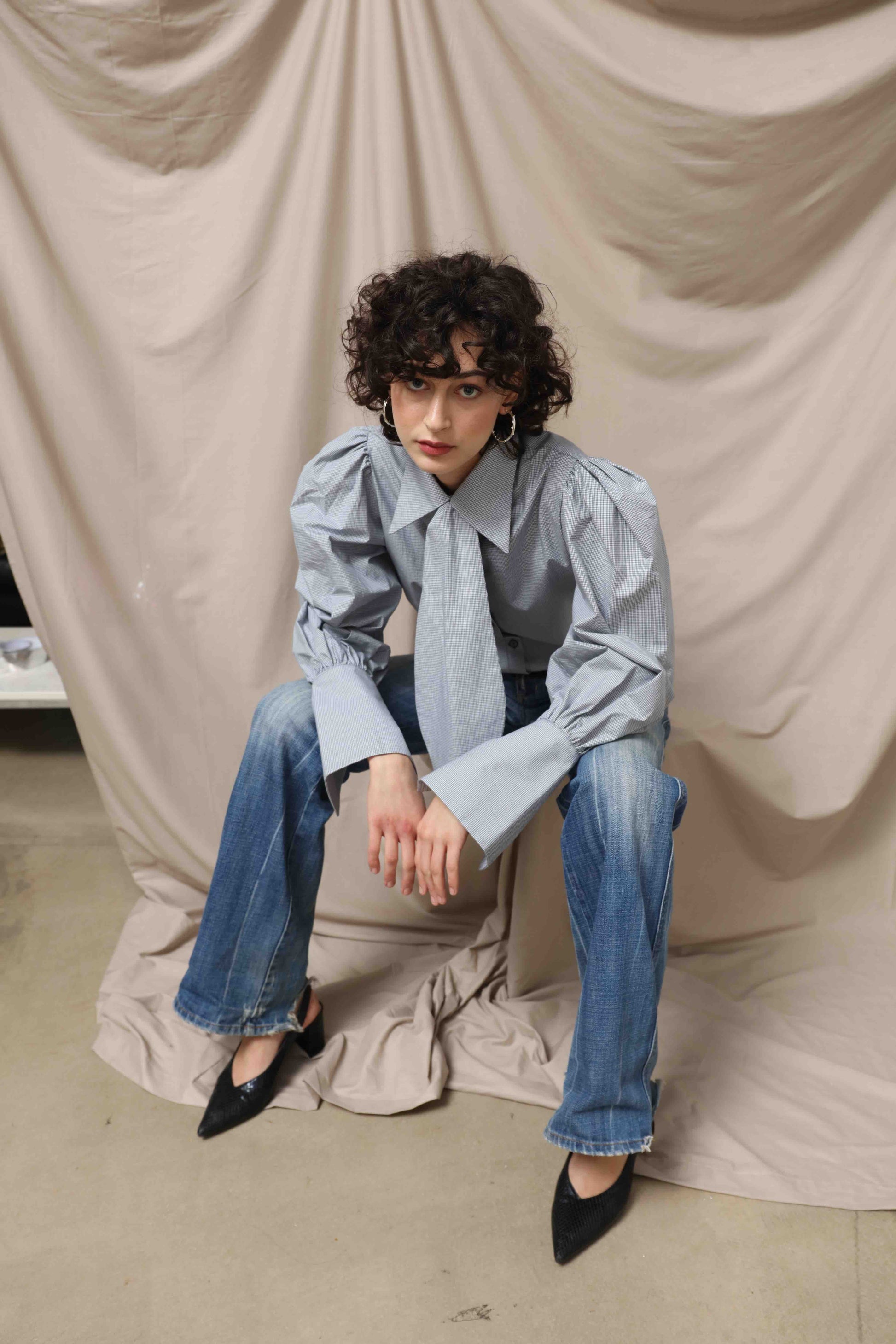  Karin Check Shirt by House of Woven Stories, handcrafted in Italy from 100% organic cotton, featuring puffed sleeves, a detachable tie, and a refined check pattern – a timeless, sustainable wardrobe piece.