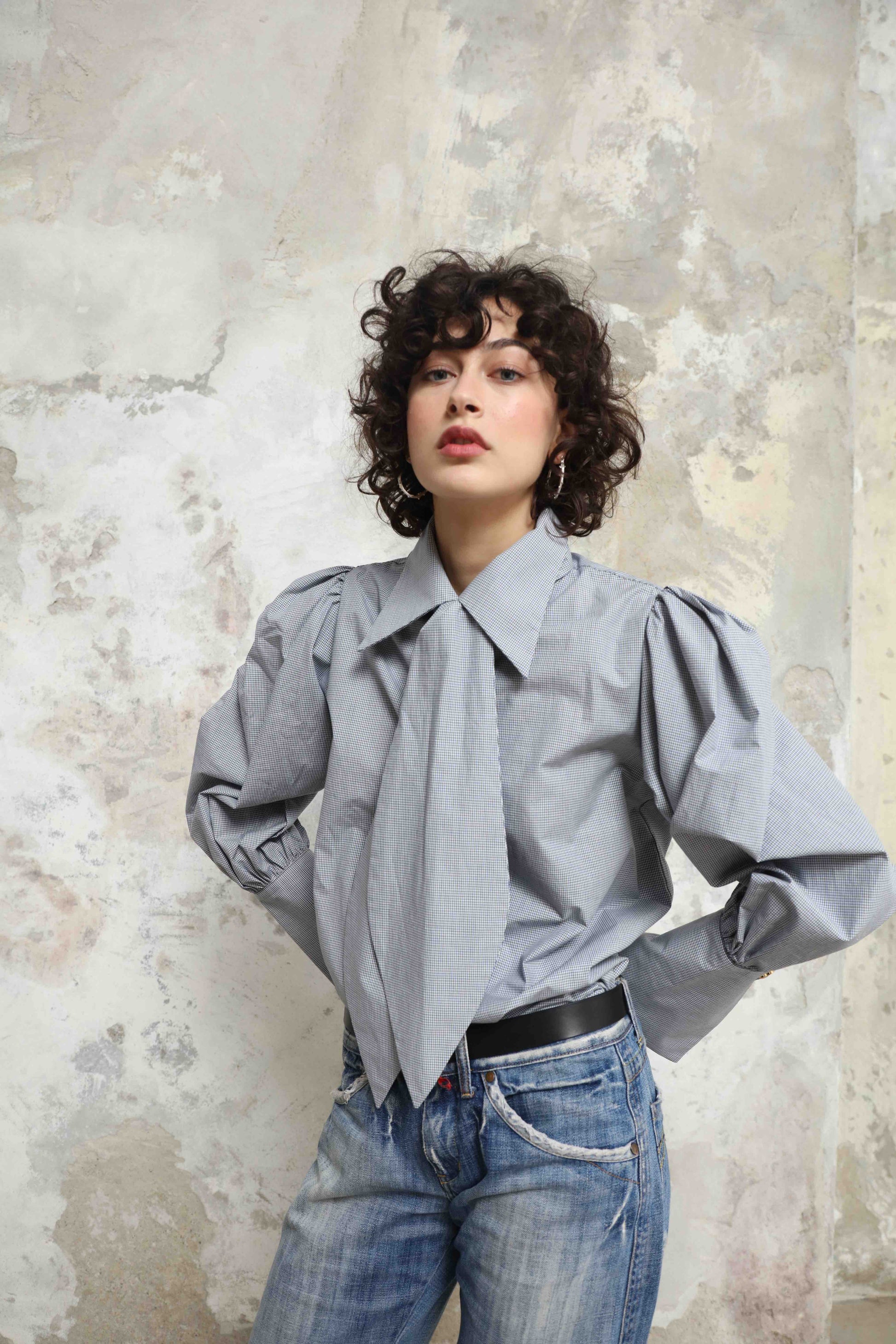 Karin Check Shirt by House of Woven Stories, handcrafted in Italy from 100% organic cotton, featuring puffed sleeves, a detachable tie, and a refined check pattern – a timeless, sustainable wardrobe piece.