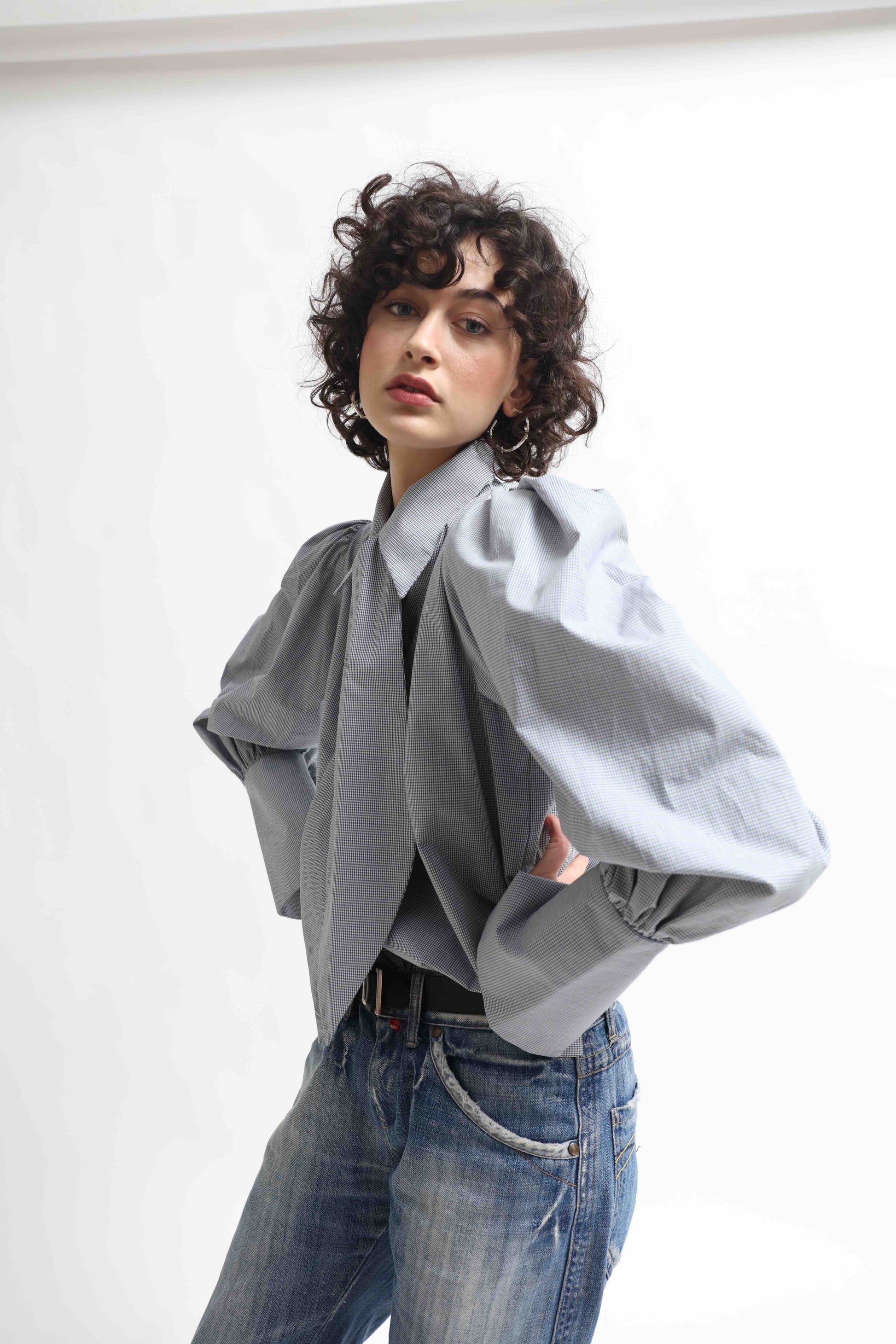 Karin Check Shirt by House of Woven Stories, handcrafted in Italy from 100% organic cotton, featuring puffed sleeves, a detachable tie, and a refined check pattern – a timeless, sustainable wardrobe piece.