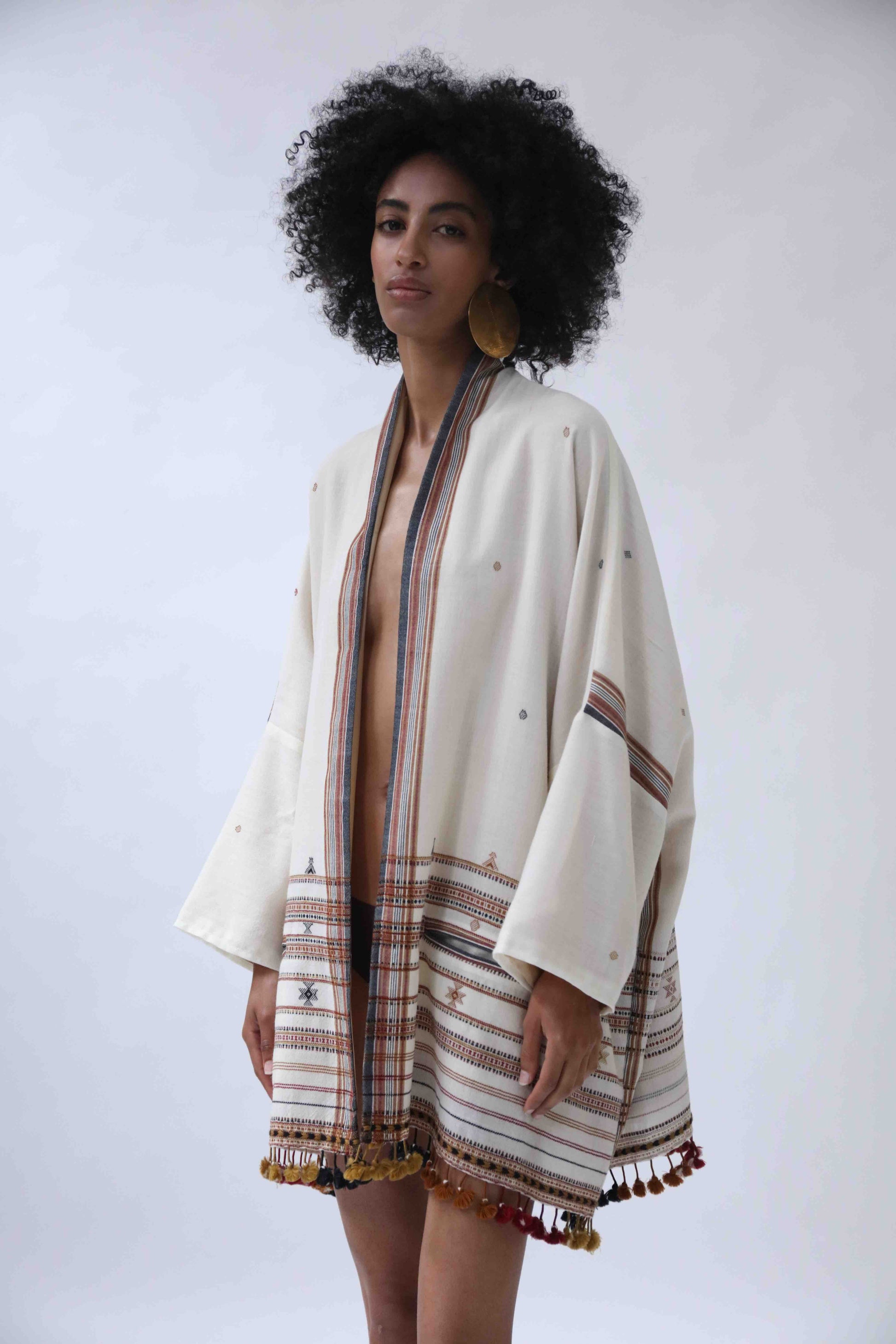 Model wearing the Kyoto Kimono Jacket in off-white handwoven merino wool with natural indigo patterns, lined in pure silk. Oversized fit, artisanal details, and bohemian elegance by House of Woven Stories.