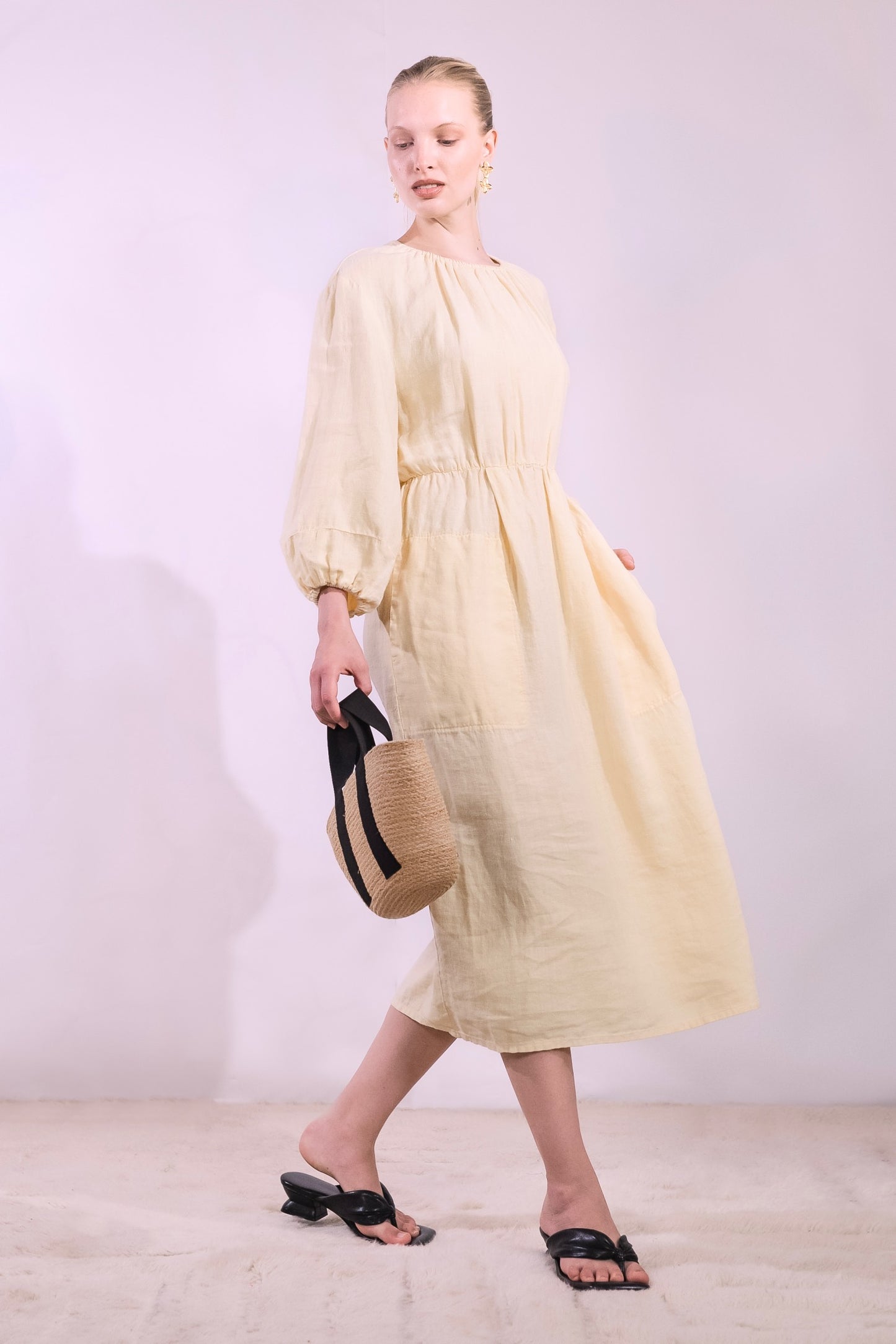 Model is wearing La Robe Bohème in banana yellow linen by Happy Haus - a timeless, feminine midi dress crafted from sustainable fabric with an effortless Parisian feel. Part of House of Woven Stories selection.