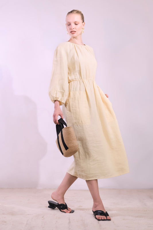 Model is wearing La Robe Bohème in banana yellow linen by Happy Haus - a timeless, feminine midi dress crafted from sustainable fabric with an effortless Parisian feel. Part of House of Woven Stories selection.