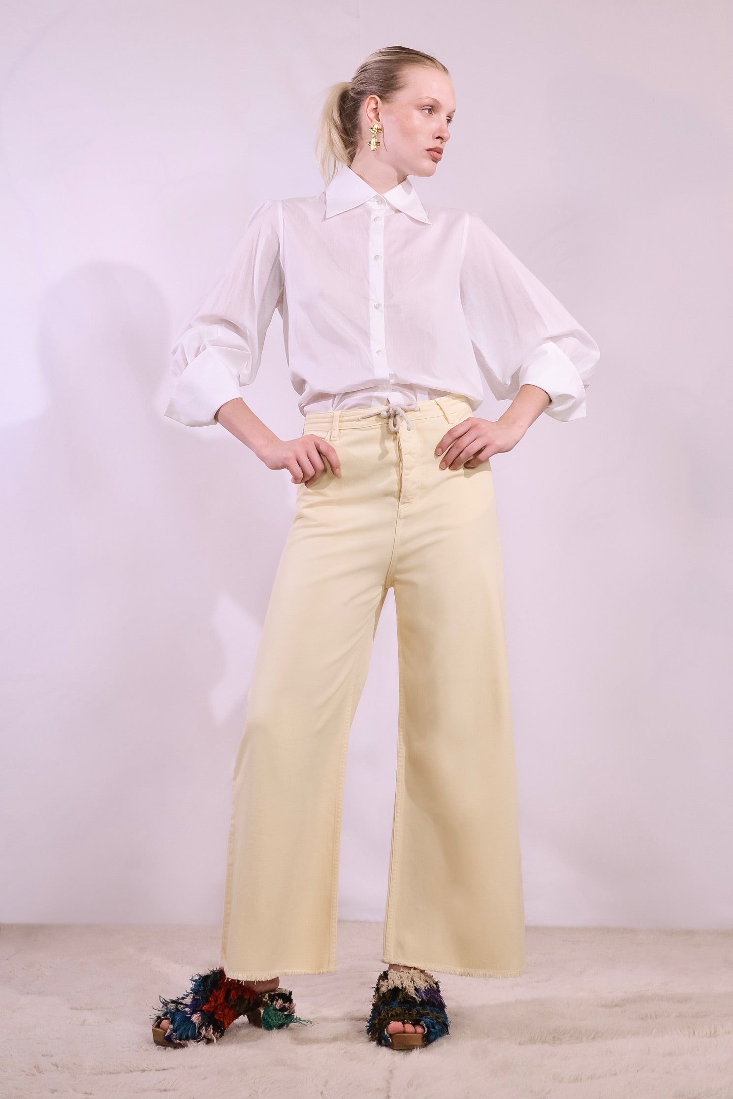 Model is wearing the Le Pantalon Oversize by Happy Haus. Wide-leg, regular-length cotton trousers with five pockets and wooden buttons, combining relaxed fit with eco-conscious design.