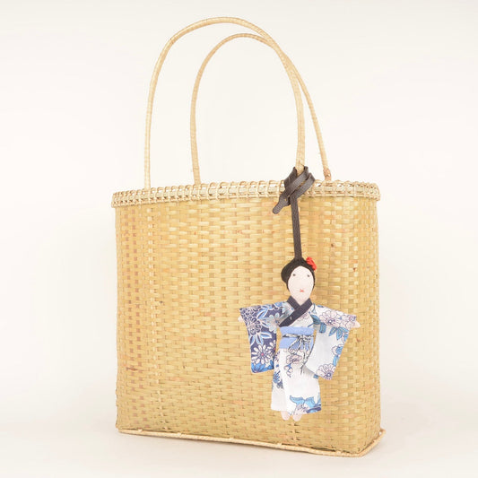 Mizu kimono fabric charm handcrafted by Afghan women artisans, shown attached to a bag, made from upcycled fabric with traditional kimono design and pink rose detail.