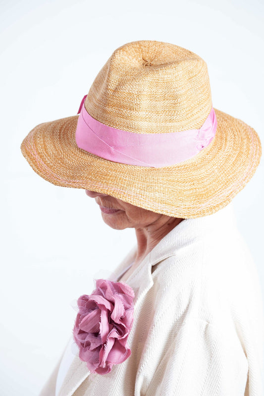 Natural straw-look paper hat with grosgrain ribbon by Lola Hats, handcrafted and adjustable for perfect fit. Available at House of Woven Stories.