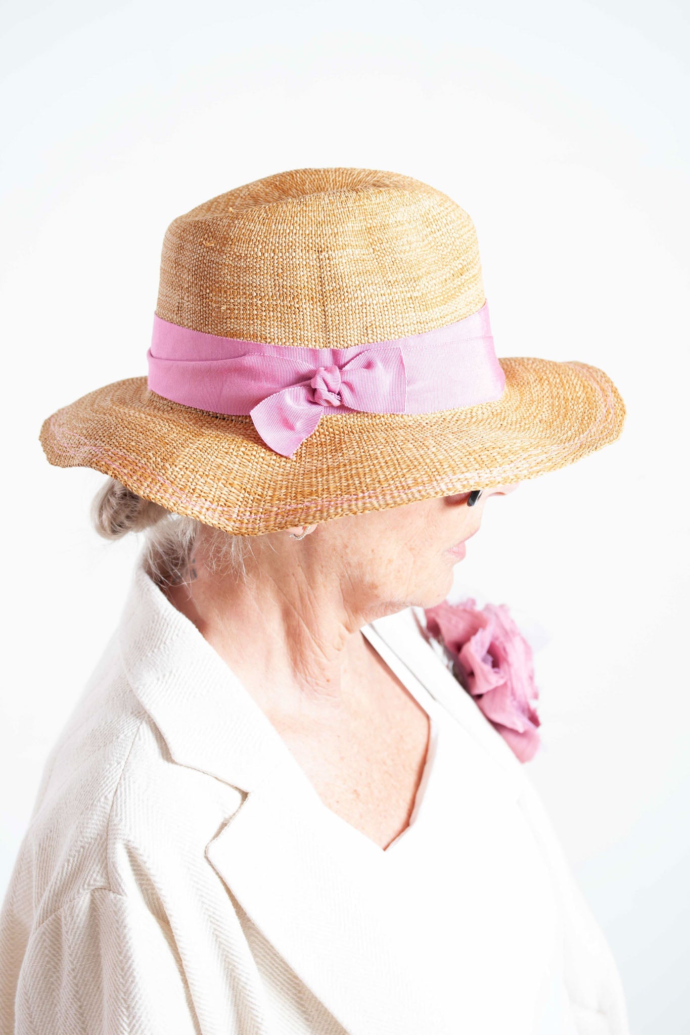 Natural straw-look paper hat with grosgrain ribbon by Lola Hats, handcrafted and adjustable for perfect fit. Available at House of Woven Stories.