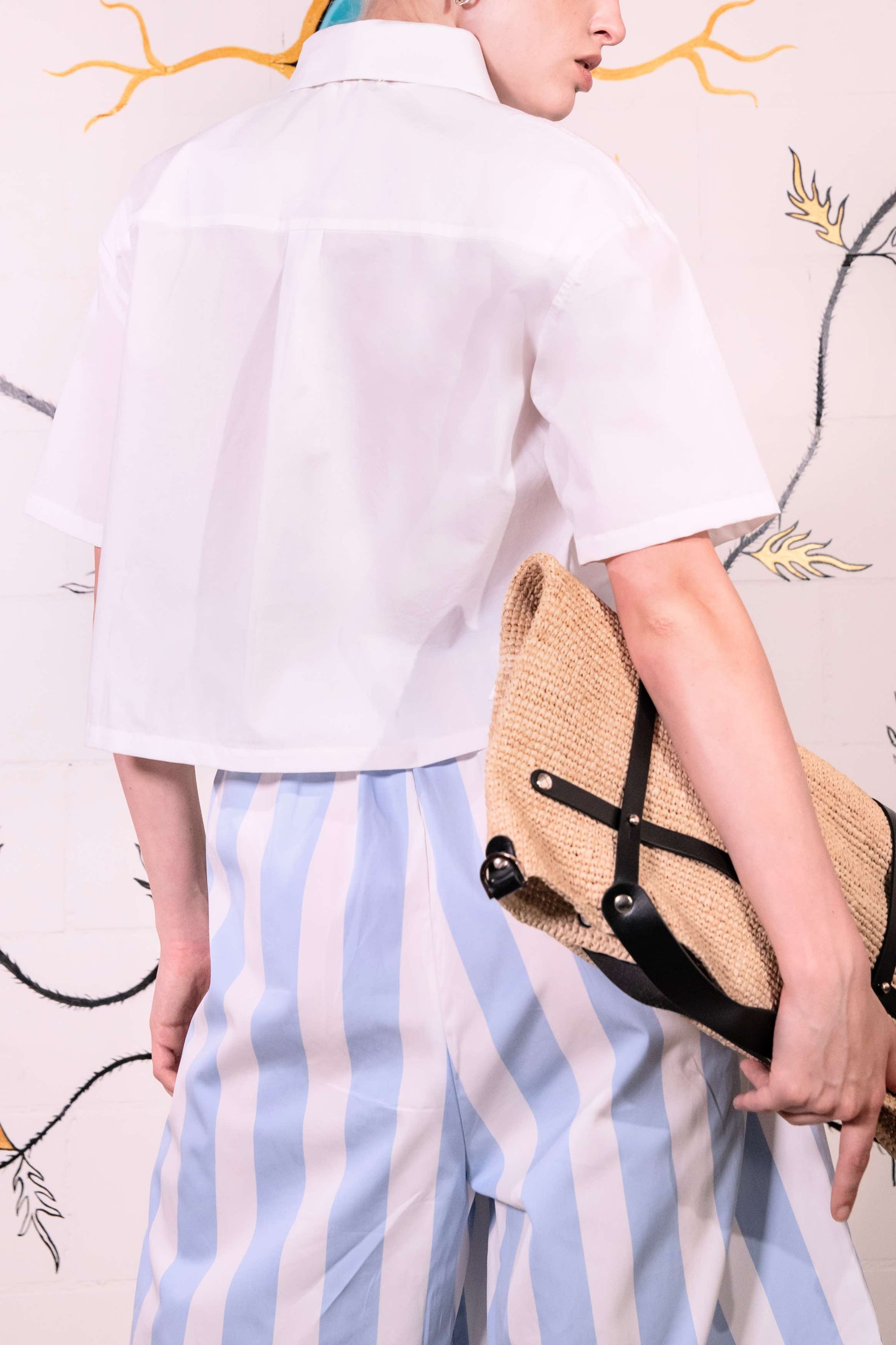 Model wearing a cropped optic white pure cotton shirt with a clean, structured fit; handmade in Italy by House of Woven Stories.