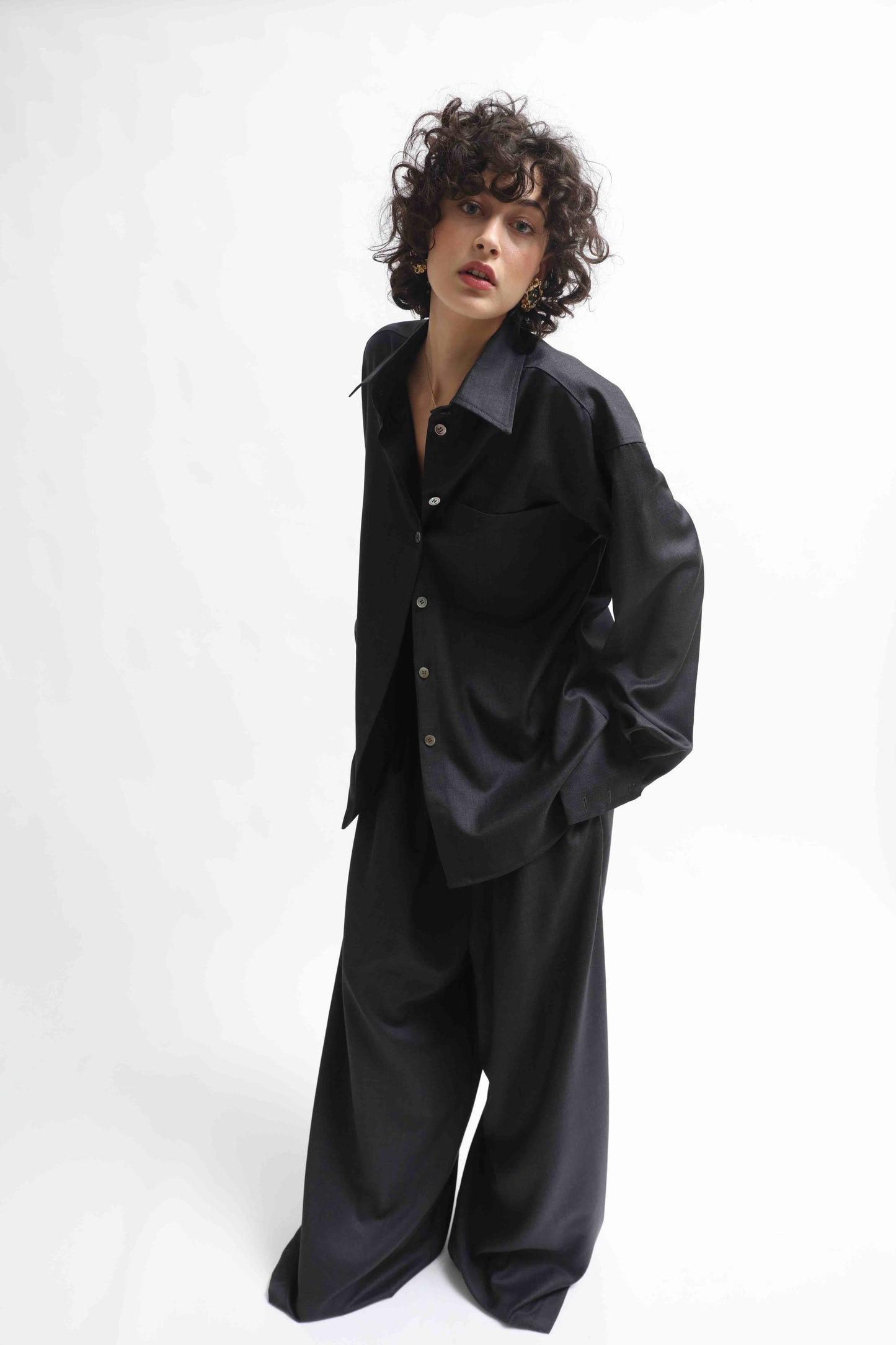 Model is wearing the Anthracite Oscar Shirt by House of Woven Stories, made from 100% Pure Merino Cool Wool with a classic collar and minimalist silhouette.