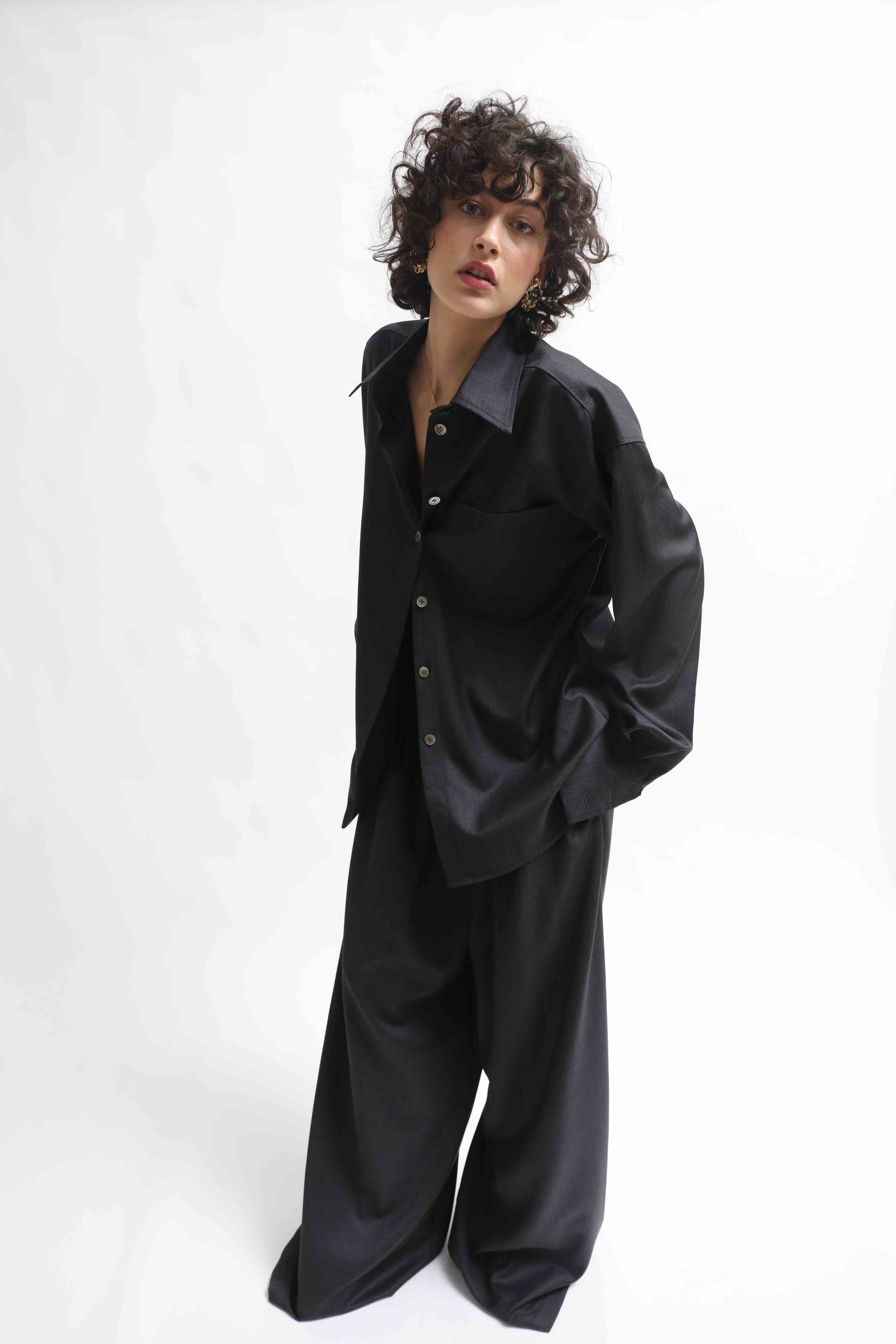 Model is wearing the Anthracite Oscar Shirt by House of Woven Stories, made from 100% Pure Merino Cool Wool with a classic collar and minimalist silhouette.