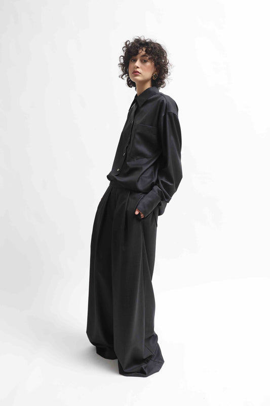 Wide-leg cool wool trousers in 100% Super 100 Pure Merino Wool with elastic waistband and front pleats, handmade in Italy by House of Woven Stories, shown in Anthracite.