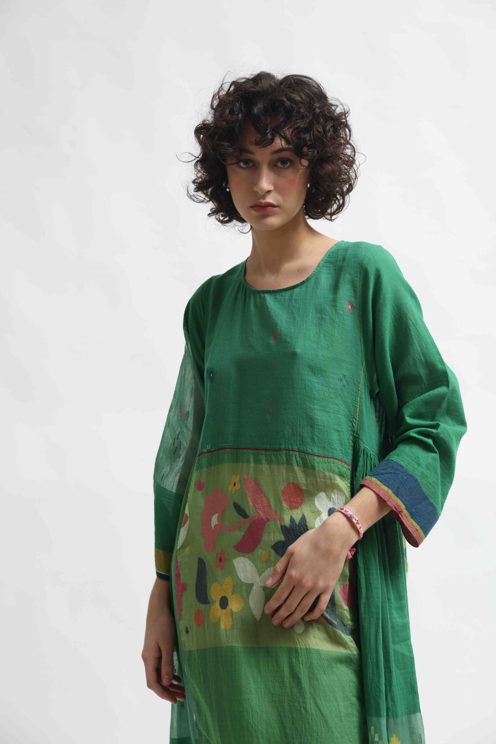 Model wearing the Rasa 01 midi dress by Injiri, handcrafted in India from pure cotton with delicate handprinted floral details on the lower half. Lightweight, artisanal, and timeless.