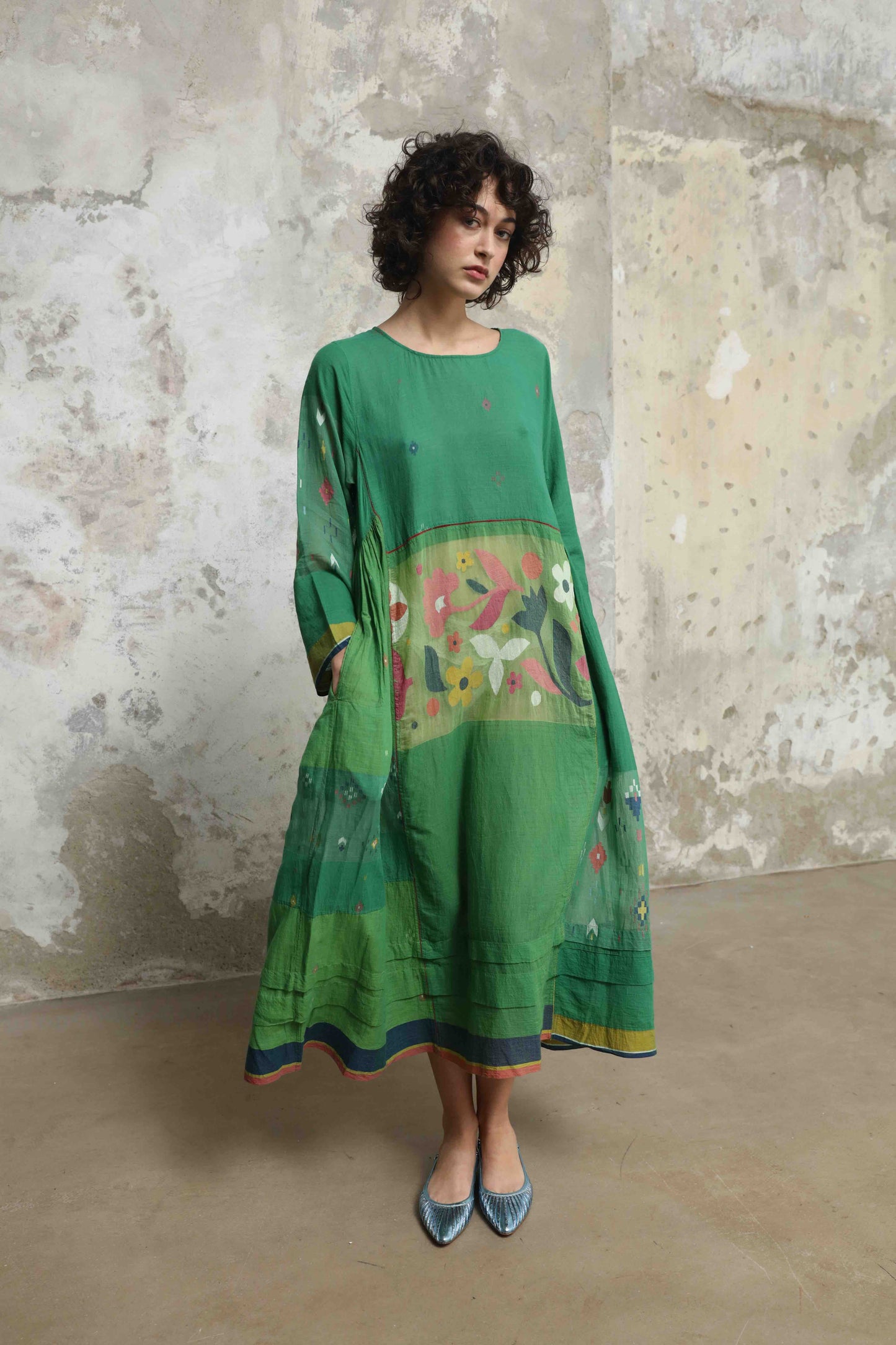 Model wearing the Rasa 01 midi dress by Injiri, handcrafted in India from pure cotton with delicate handprinted floral details on the lower half. Lightweight, artisanal, and timeless.