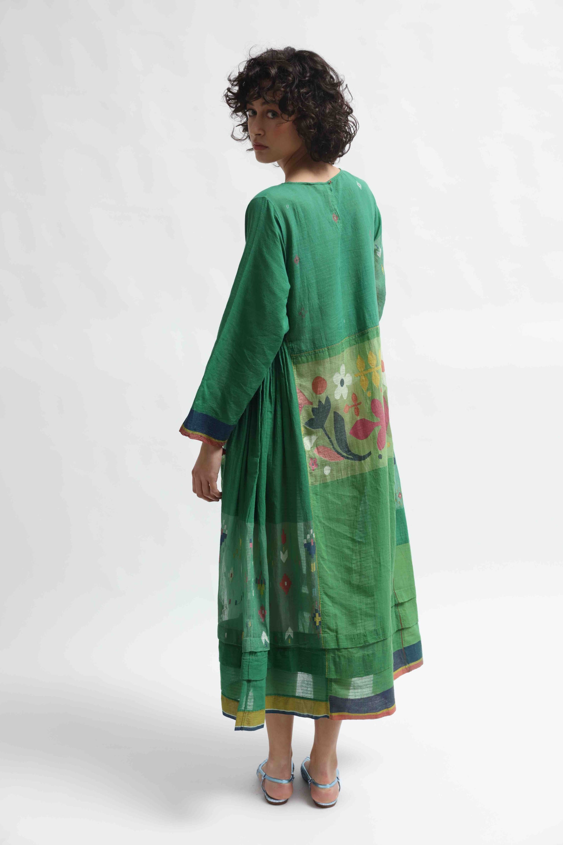 Model wearing the Rasa 01 midi dress by Injiri, handcrafted in India from pure cotton with delicate handprinted floral details on the lower half. Lightweight, artisanal, and timeless.