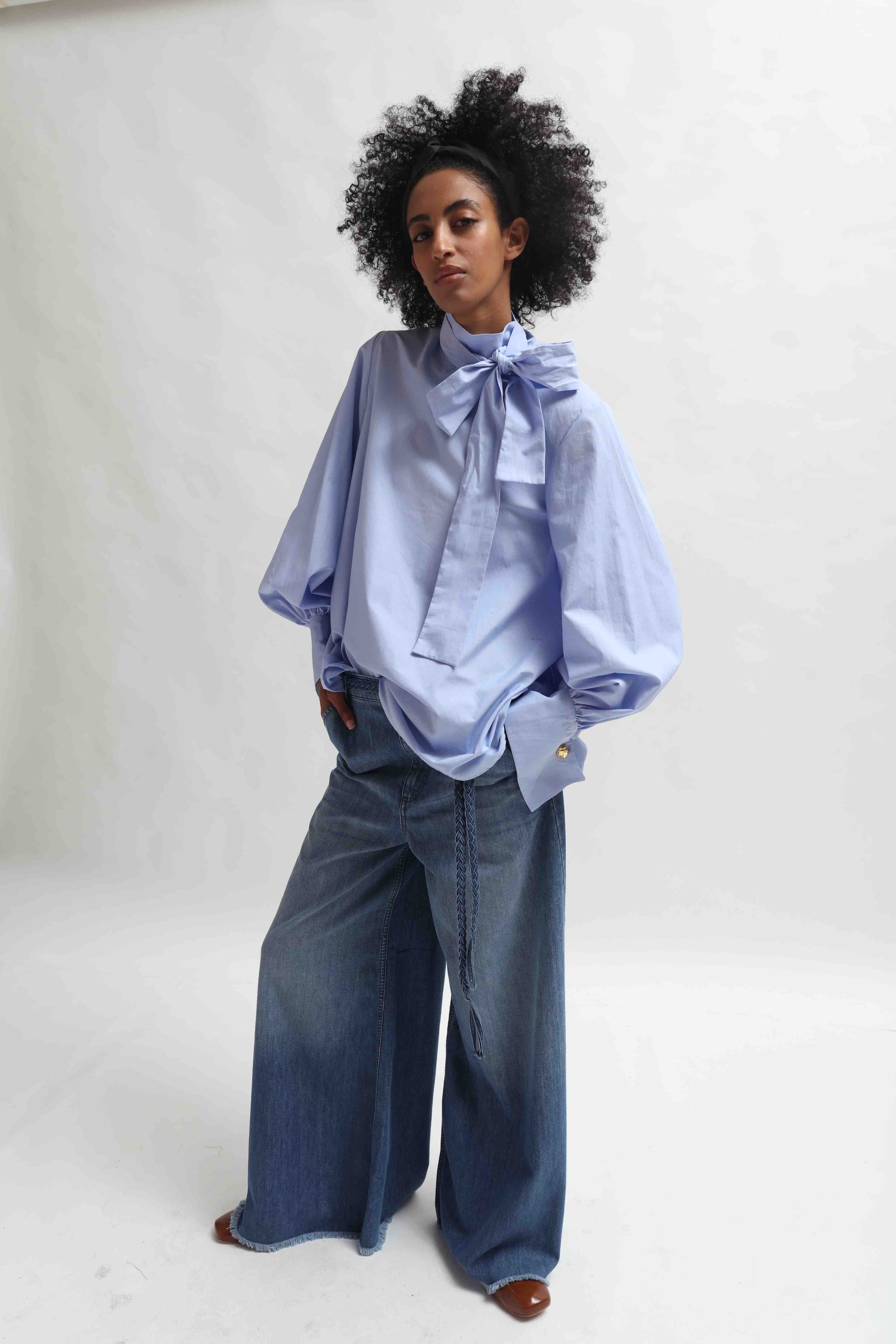 Sky Blue organic cotton blouse by House of Woven Stories, featuring a signature adjustable tie-neck detail. Ethically made in Italy in small batches from soft, premium poplin.