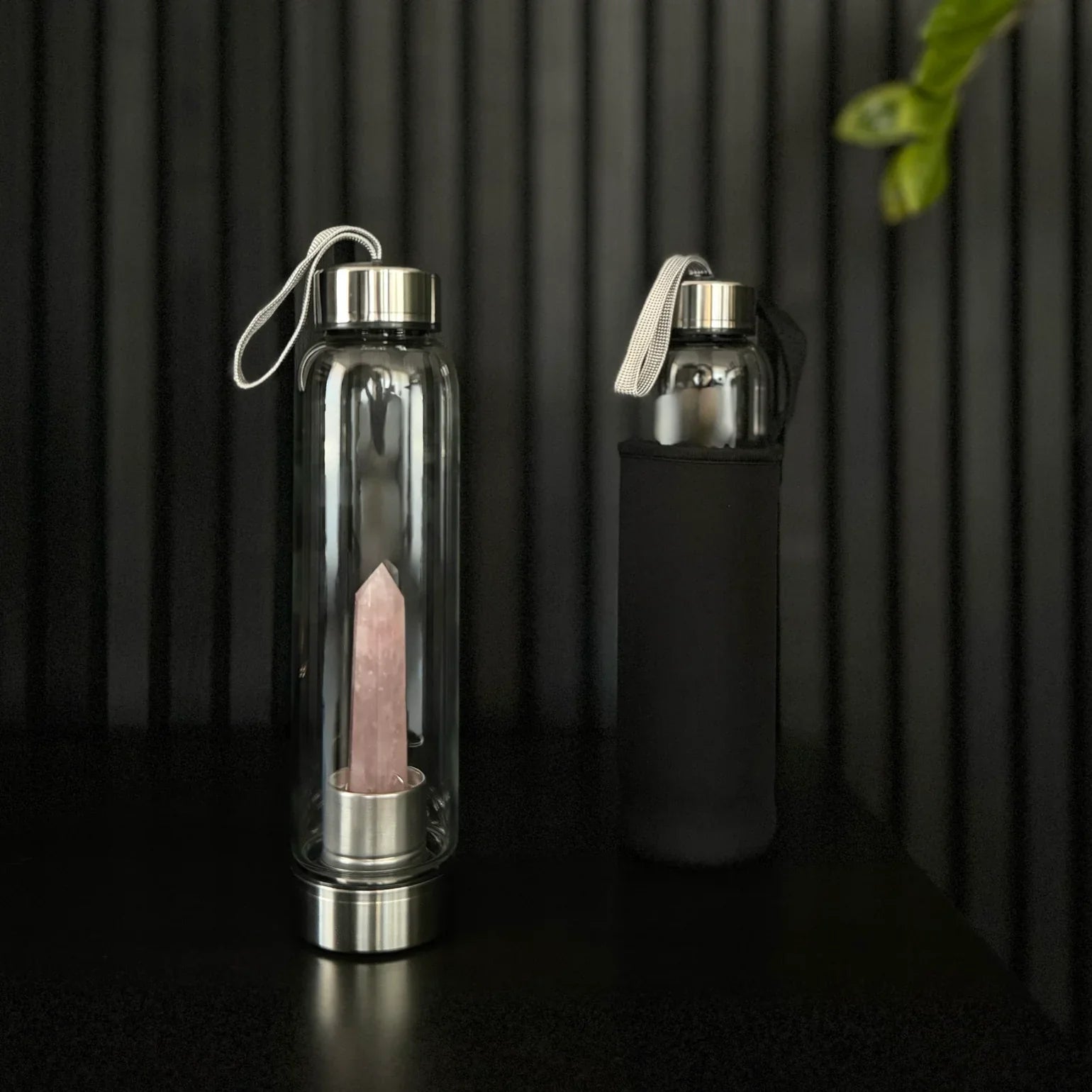 Rose Quartz Crystal Water Bottle by The Goddess Collective, featuring a natural crystal obelisk inside a glass bottle with stainless steel lids and carry sleeve.