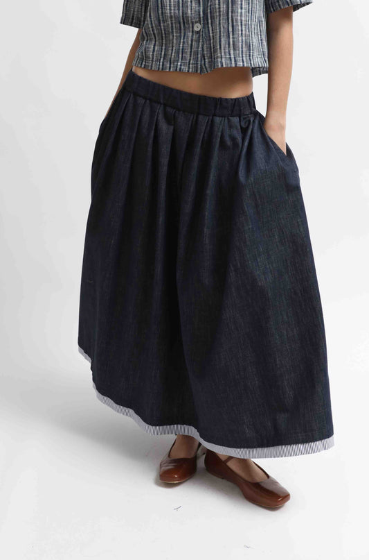 Seul Denim Skirt with striped cotton details and side pockets, handcrafted in Italy by House of Woven Stories. Sustainable, versatile midi skirt combining comfort and modern style.