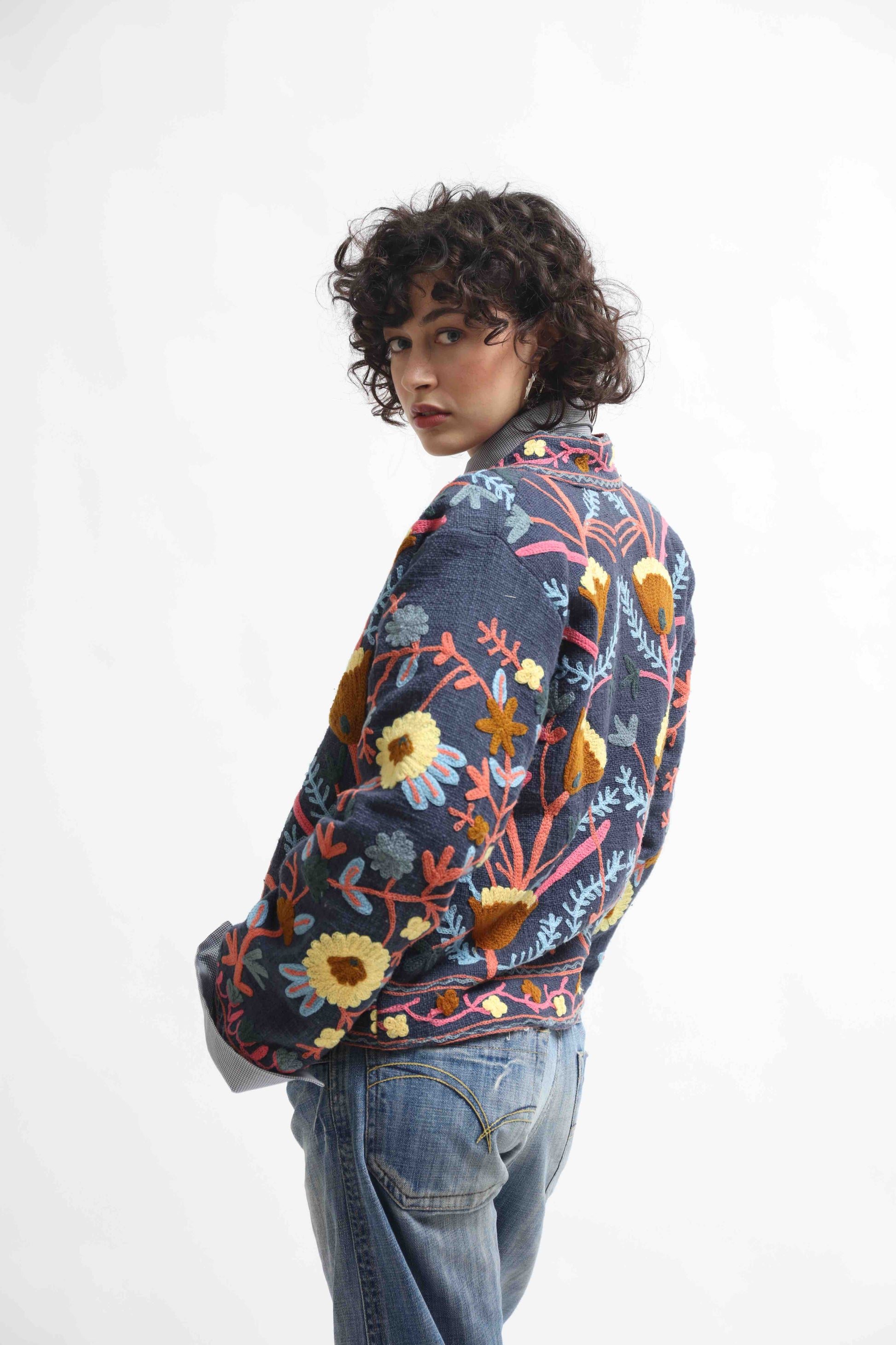 Suzani Short Jacket by House of Woven Stories. Hand-embroidered 100% cotton jacket with traditional Indian Suzani embroidery, lined with upcycled silk from antique saris, crafted sustainably in Italy.