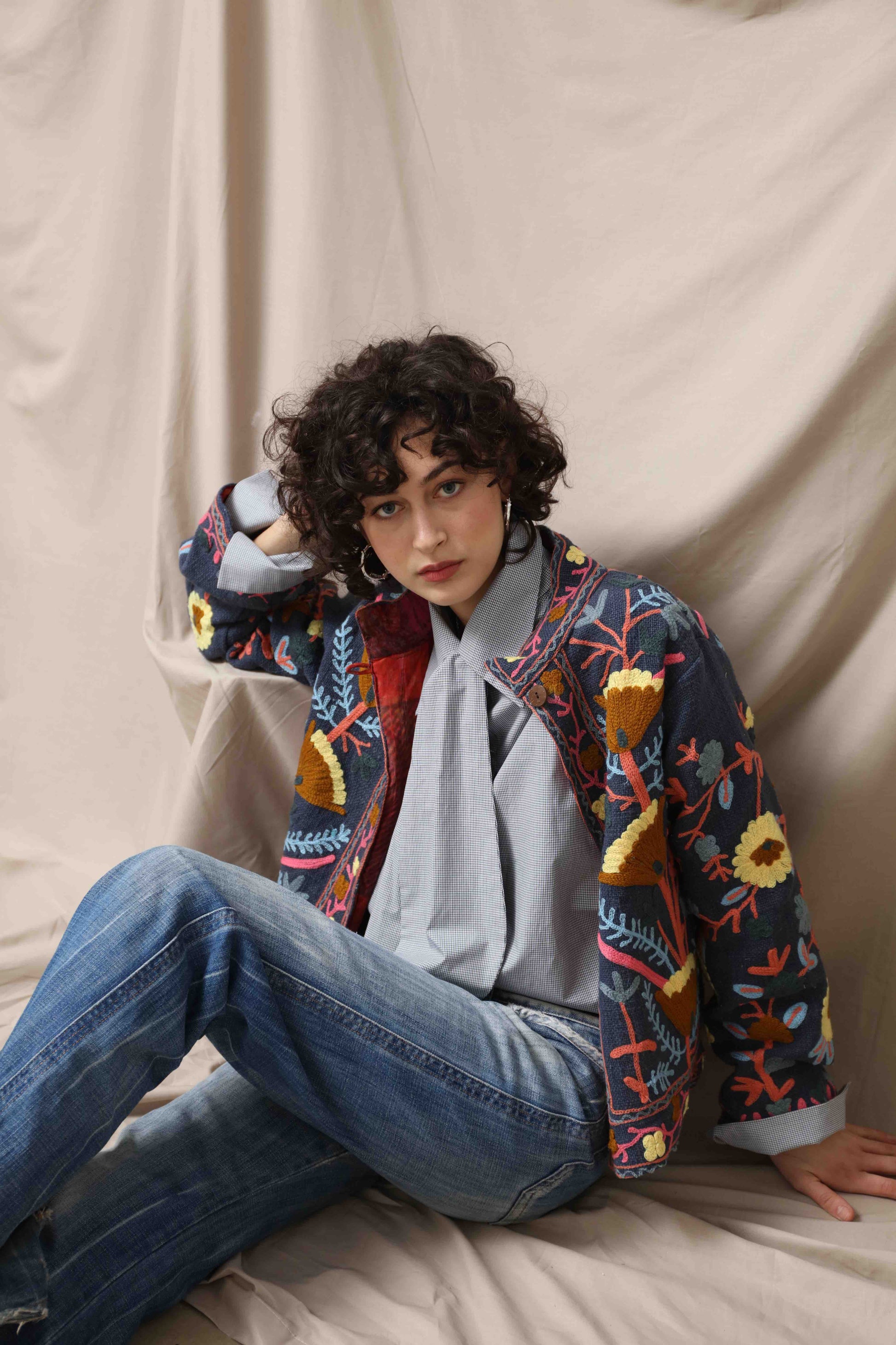 Suzani Short Jacket by House of Woven Stories. Hand-embroidered 100% cotton jacket with traditional Indian Suzani embroidery, lined with upcycled silk from antique saris, crafted sustainably in Italy.