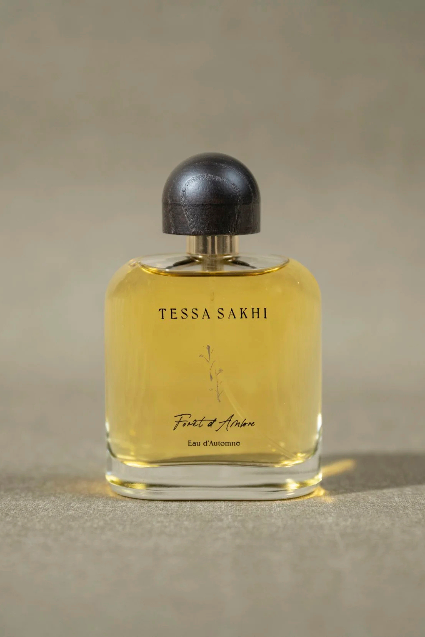 Bottle of Forêt d’Ambre – Eau d’Automne by Tessa Sakhi, a unisex amber and woody Eau de Parfum with notes of white pepper, patchouli, labdanum, tonka bean, and musk. A balancing and soothing fragrance curated by House of Nomad Stories.