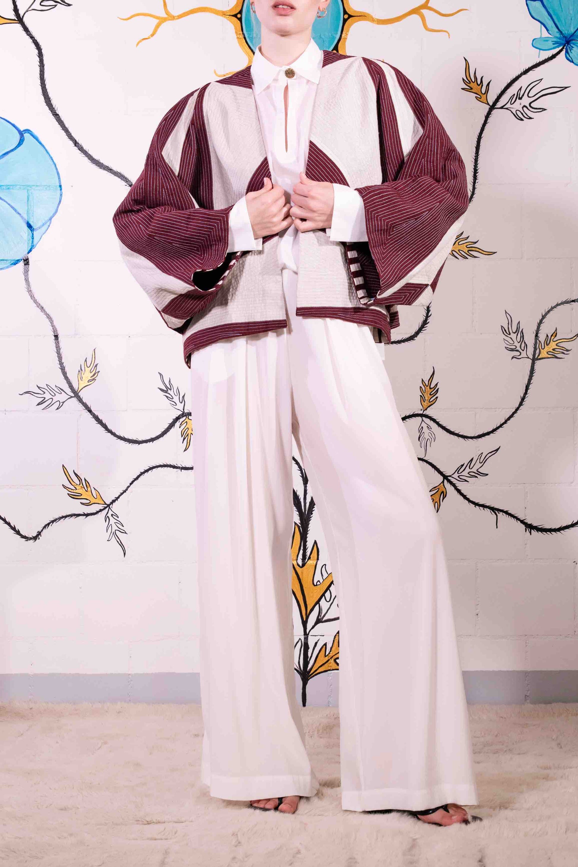 Cropped jacket in heavyweight organic cotton with hand-applied appliqué and embroidery by Ka-Sha. Features fabric button closure and easy-fit silhouette. Ethically handcrafted in India.