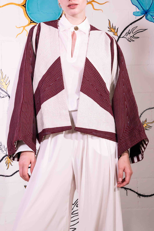 Cropped jacket in heavyweight organic cotton with hand-applied appliqué and embroidery by Ka-Sha. Features fabric button closure and easy-fit silhouette. Ethically handcrafted in India.
