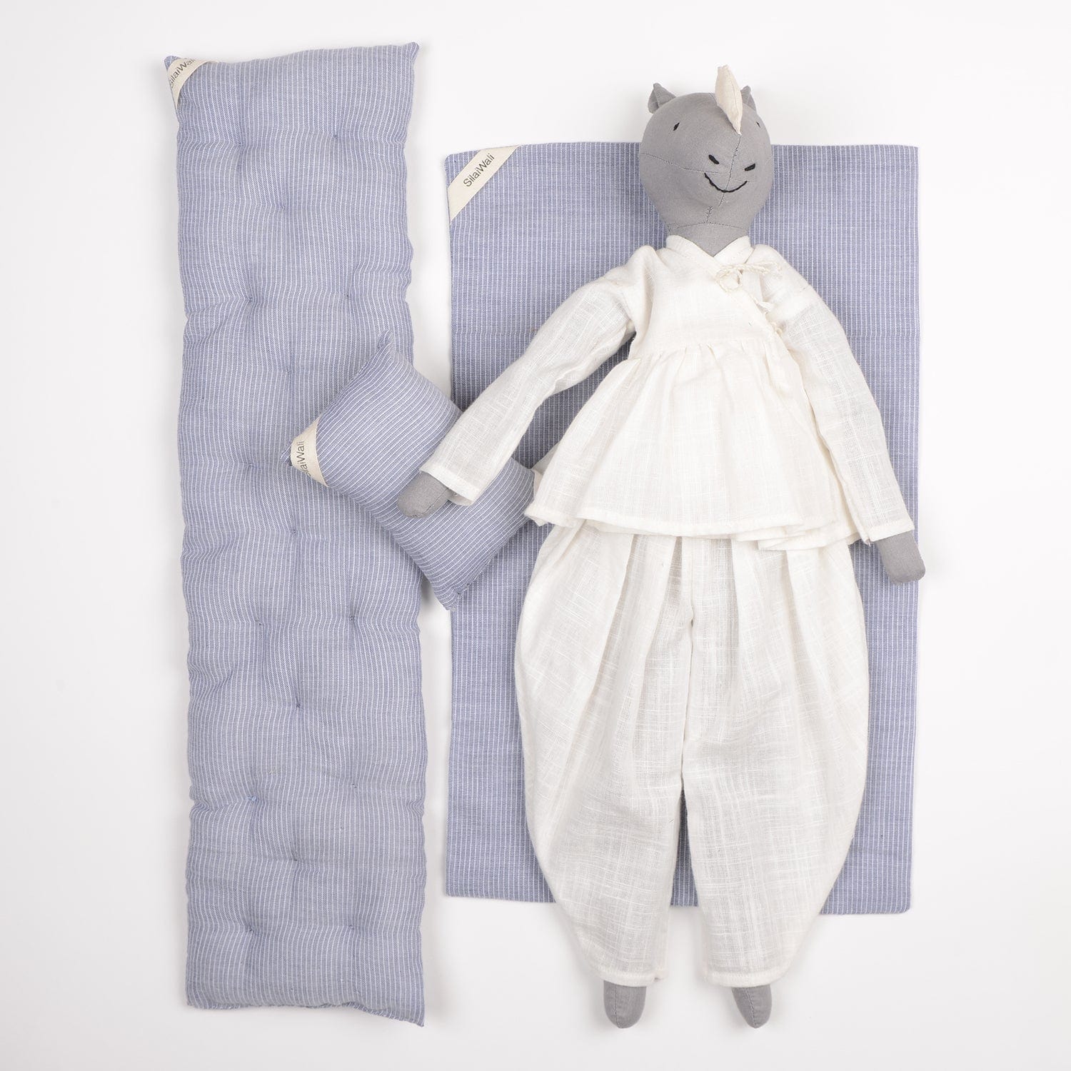 Ura handcrafted rhinoceros cloth doll made from upcycled fabric by SilaiWali, with bedding in foldable box. Available at House of Woven Stories.