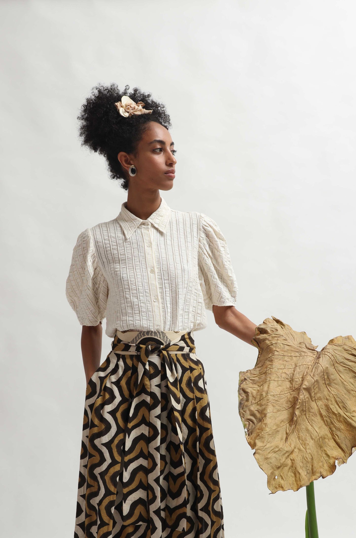 Structured puff-sleeve blouse crafted from upcycled cotton waste and T-shirt scraps, featuring a breathable leno weave. Handmade by Paiwand, combining traditional techniques with sustainable materials for a unique, eco-friendly garment.