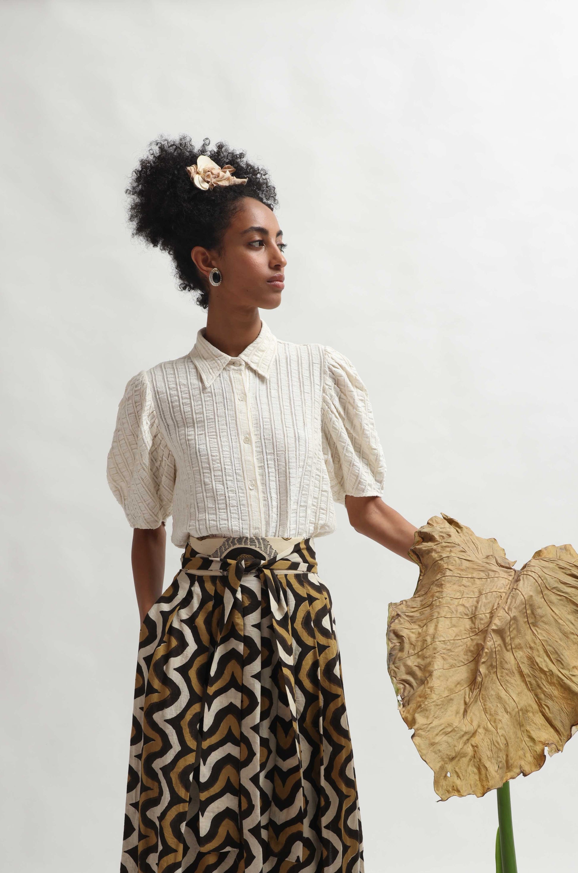 Structured puff-sleeve blouse crafted from upcycled cotton waste and T-shirt scraps, featuring a breathable leno weave. Handmade by Paiwand, combining traditional techniques with sustainable materials for a unique, eco-friendly garment.