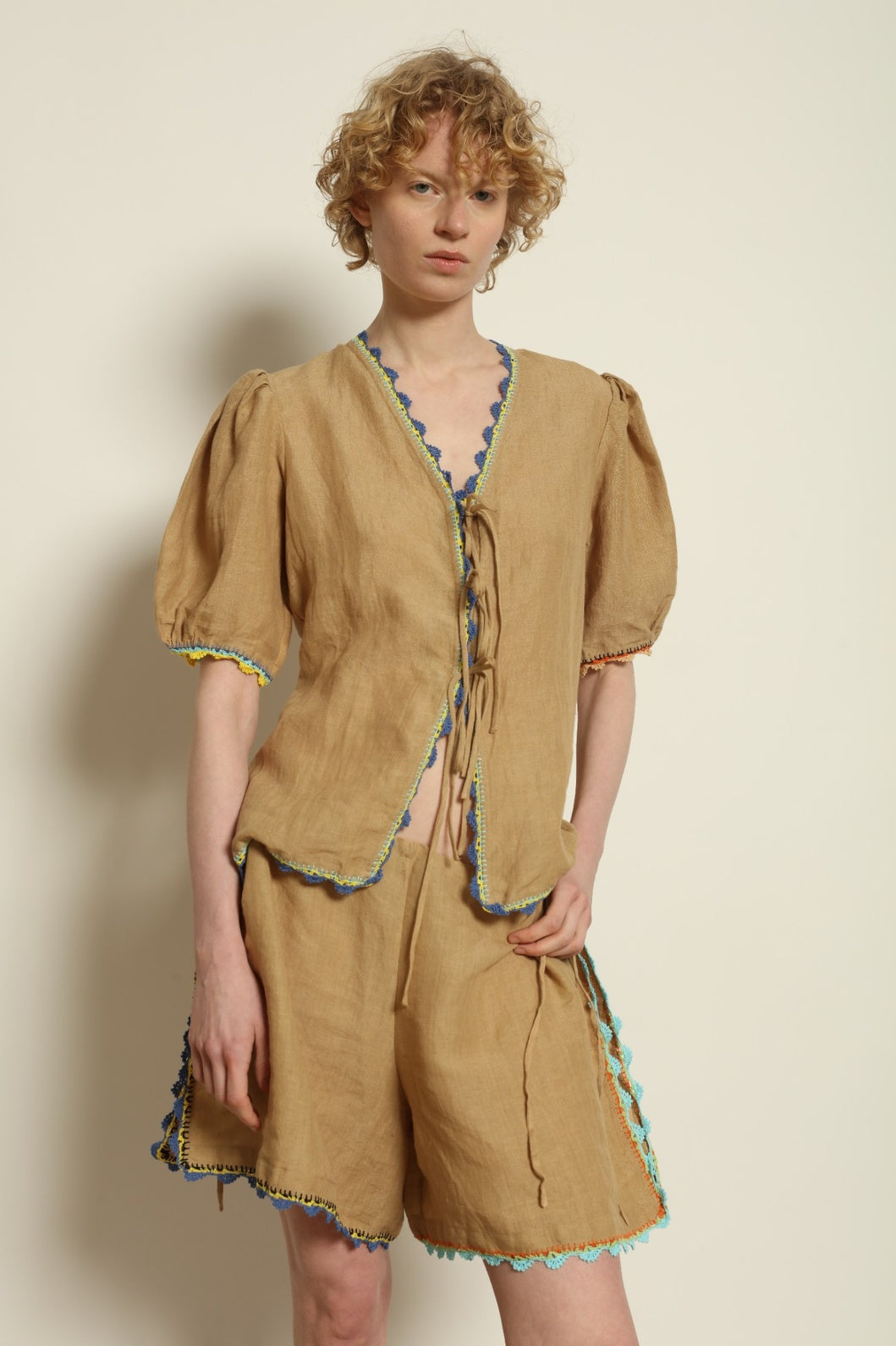 Model is wearing the Agata Beige Linen Set by Supernaturae x HONS in warm sandy beige botanical-dyed linen, featuring a refined two-piece silhouette with structured yet relaxed tailoring. This sustainable slow fashion set shows natural tonal variations unique to each garment, crafted through small-batch production in Mexico using ancestral techniques and natural fibers, part of the House of Nomad Stories selection.