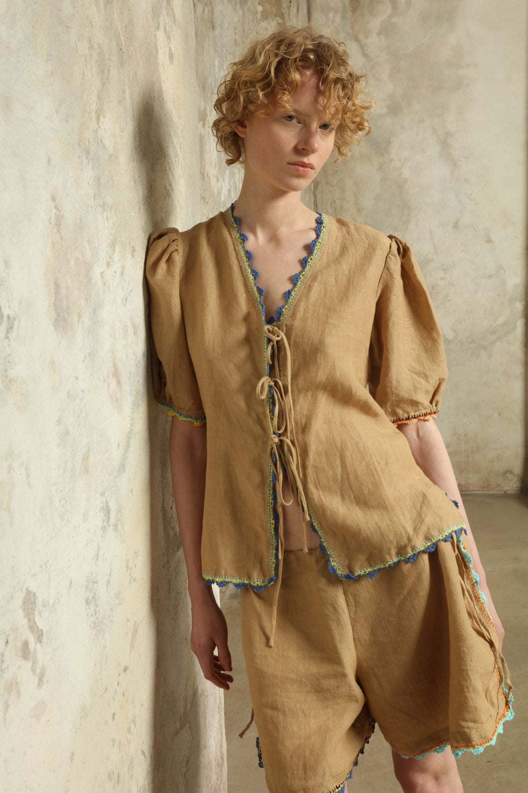 Model is wearing the Agata Beige Linen Set by Supernaturae x HONS in warm sandy beige botanical-dyed linen, featuring a refined two-piece silhouette with structured yet relaxed tailoring. This sustainable slow fashion set shows natural tonal variations unique to each garment, crafted through small-batch production in Mexico using ancestral techniques and natural fibers, part of the House of Nomad Stories selection.