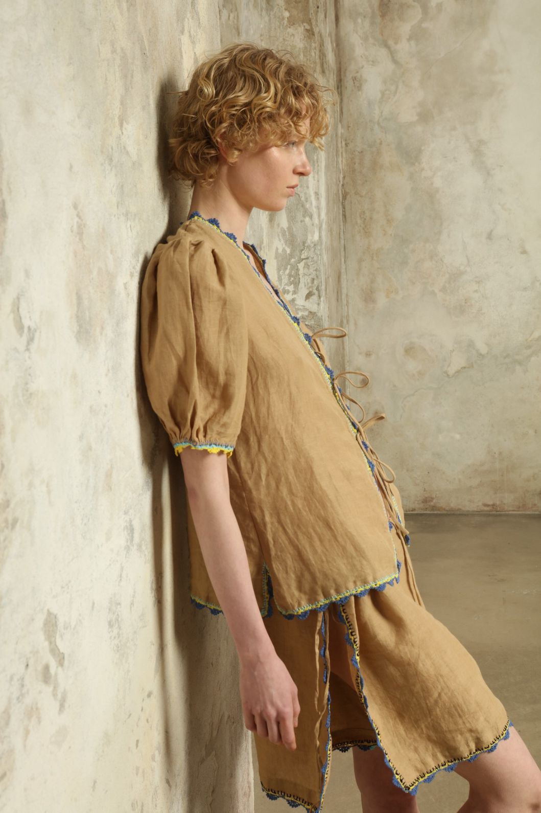 Model is wearing the Agata Beige Linen Set by Supernaturae x HONS in warm sandy beige botanical-dyed linen, featuring a refined two-piece silhouette with structured yet relaxed tailoring. This sustainable slow fashion set shows natural tonal variations unique to each garment, crafted through small-batch production in Mexico using ancestral techniques and natural fibers, part of the House of Nomad Stories selection.