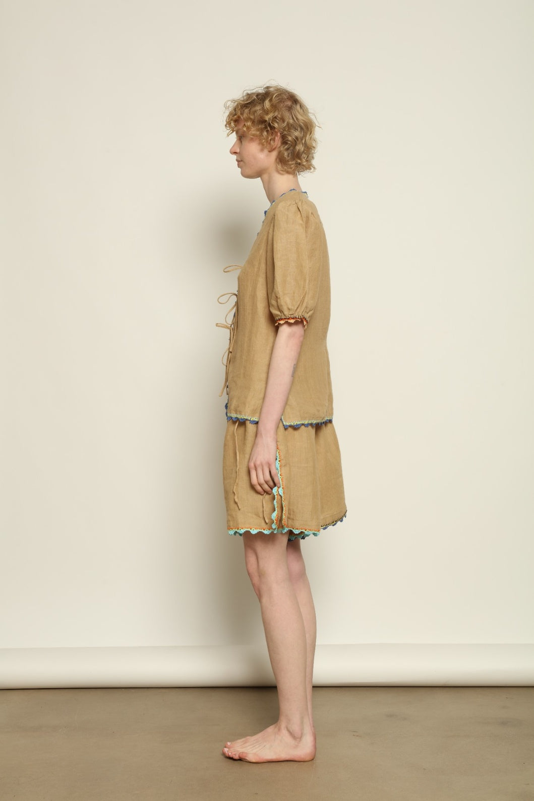 Model is wearing the Agata Beige Linen Set by Supernaturae x HONS in warm sandy beige botanical-dyed linen, featuring a refined two-piece silhouette with structured yet relaxed tailoring. This sustainable slow fashion set shows natural tonal variations unique to each garment, crafted through small-batch production in Mexico using ancestral techniques and natural fibers, part of the House of Nomad Stories selection.
