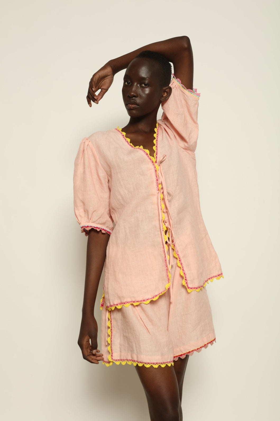 Model is wearing the Agata Pink Linen Set by Supernaturae x HONS, crafted in lightweight washed linen with soft botanical pink tones and delicate hand-crochet detailing. This sustainable summer capsule piece features a relaxed, breathable silhouette designed for effortless movement and timeless styling. Made in small-batch ethical production in Mexico, part of the House of Nomad Stories selection, worn by model 1.79m tall.