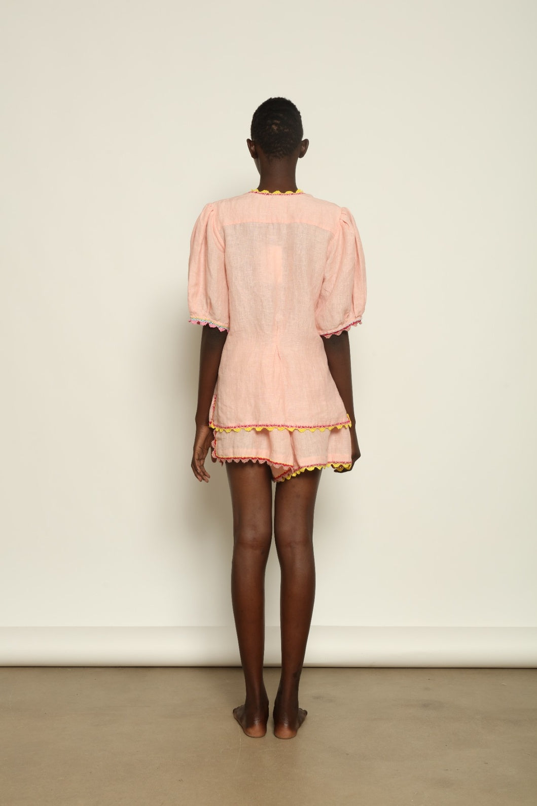 Model is wearing the Agata Pink Linen Set by Supernaturae x HONS, crafted in lightweight washed linen with soft botanical pink tones and delicate hand-crochet detailing. This sustainable summer capsule piece features a relaxed, breathable silhouette designed for effortless movement and timeless styling. Made in small-batch ethical production in Mexico, part of the House of Nomad Stories selection, worn by model 1.79m tall.