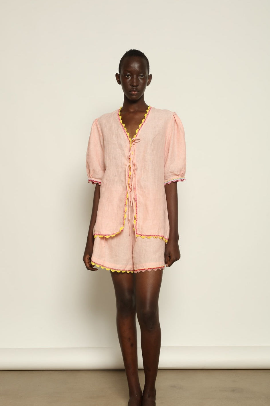 Model is wearing the Agata Pink Linen Set by Supernaturae x HONS, crafted in lightweight washed linen with soft botanical pink tones and delicate hand-crochet detailing. This sustainable summer capsule piece features a relaxed, breathable silhouette designed for effortless movement and timeless styling. Made in small-batch ethical production in Mexico, part of the House of Nomad Stories selection, worn by model 1.79m tall.