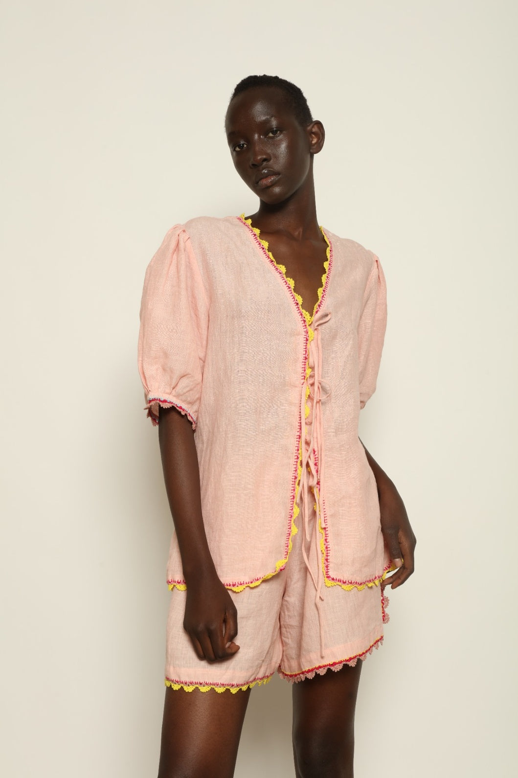 Model is wearing the Agata Pink Linen Set by Supernaturae x HONS, crafted in lightweight washed linen with soft botanical pink tones and delicate hand-crochet detailing. This sustainable summer capsule piece features a relaxed, breathable silhouette designed for effortless movement and timeless styling. Made in small-batch ethical production in Mexico, part of the House of Nomad Stories selection, worn by model 1.79m tall.