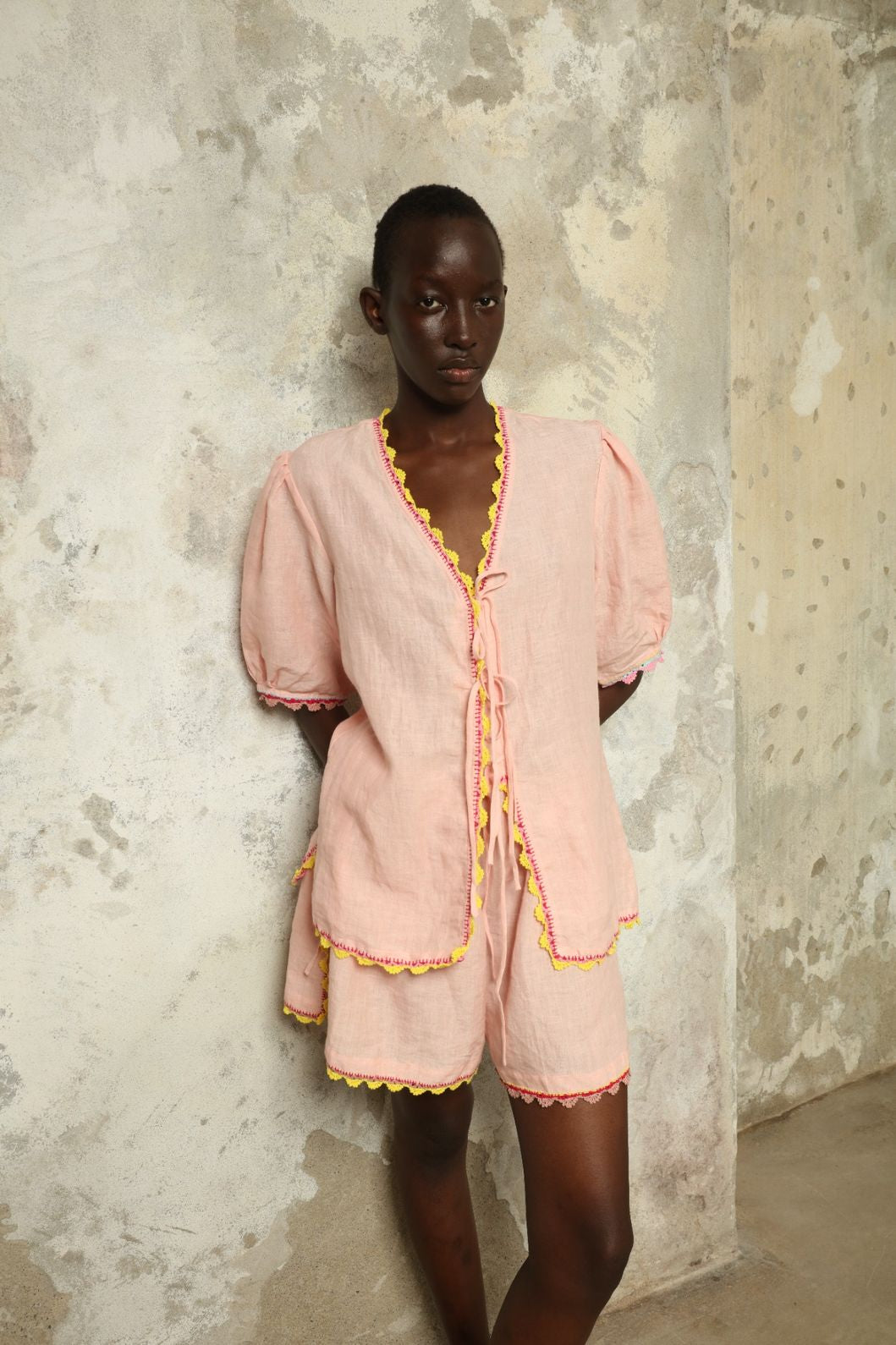 Model is wearing the Agata Pink Linen Set by Supernaturae x HONS, crafted in lightweight washed linen with soft botanical pink tones and delicate hand-crochet detailing. This sustainable summer capsule piece features a relaxed, breathable silhouette designed for effortless movement and timeless styling. Made in small-batch ethical production in Mexico, part of the House of Nomad Stories selection, worn by model 1.79m tall.