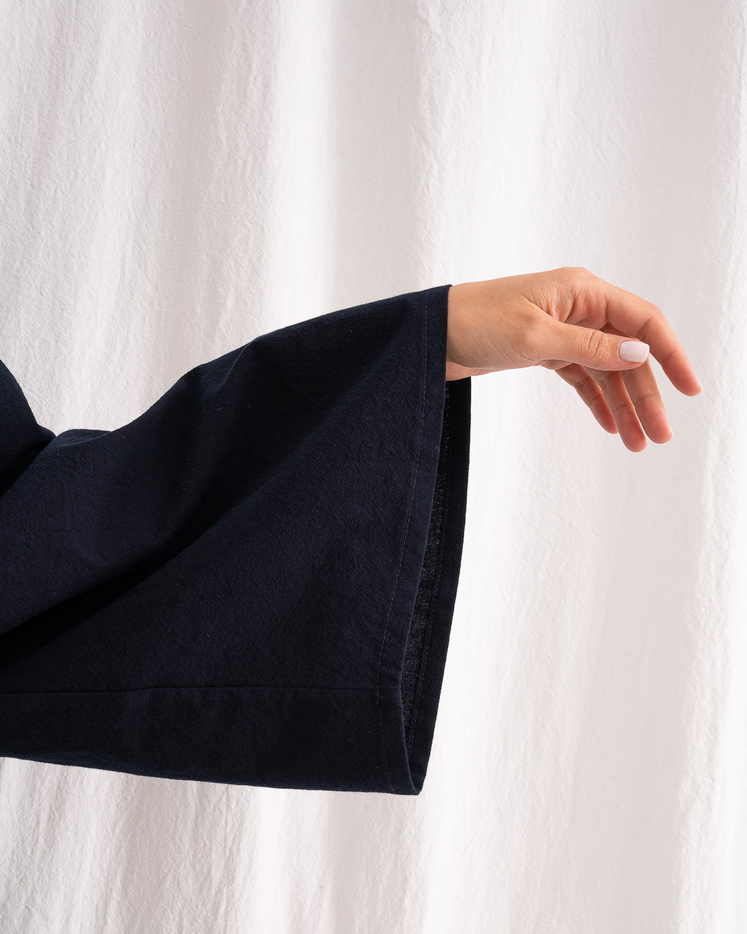 A Bigger Splash Cotton Dress by Les Vacances d’Irina, full-length long-sleeved maxi dress in ivory cotton with shell buttons, high collar, and hidden side pockets, handmade in Romania.