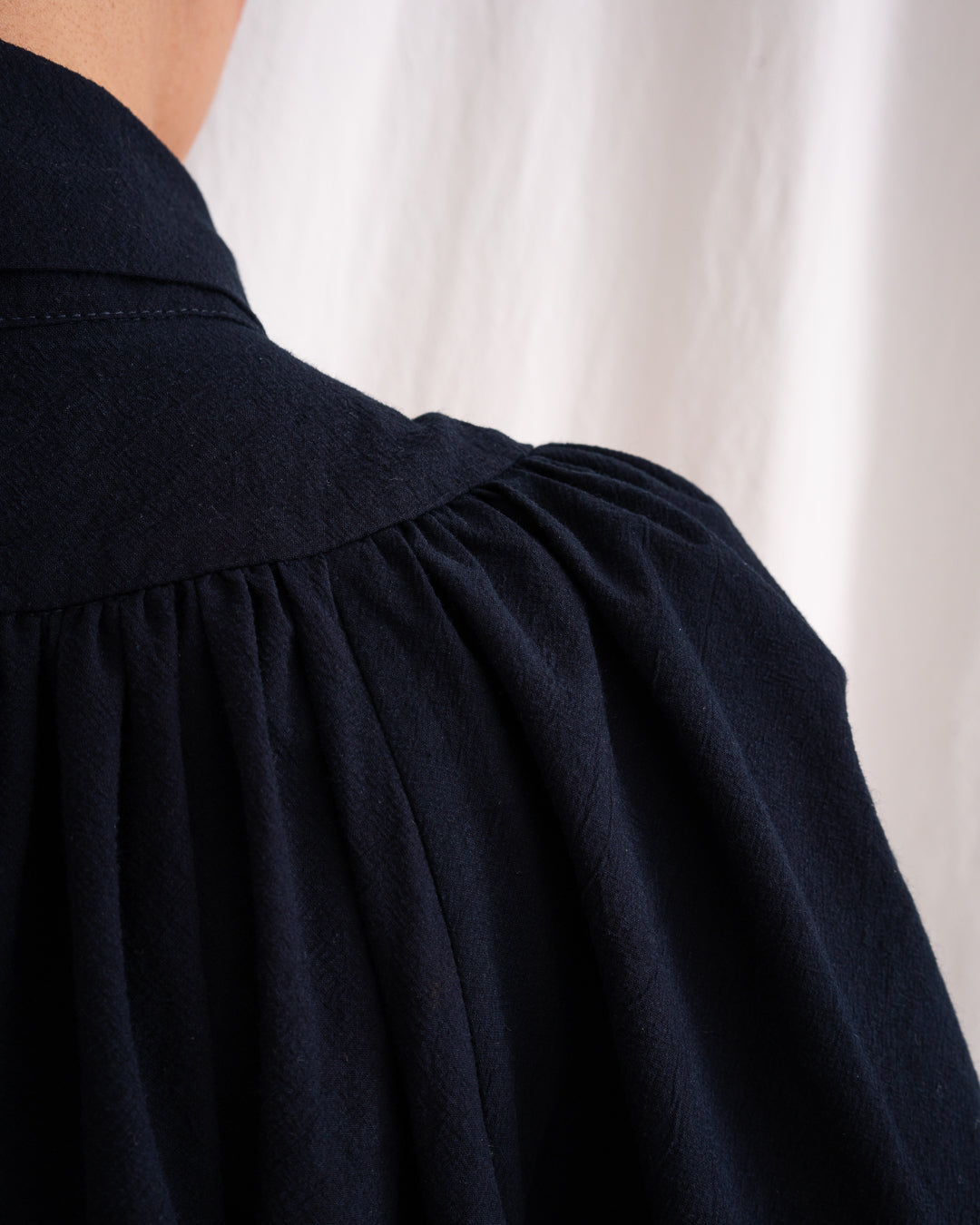 A Bigger Splash Cotton Dress by Les Vacances d’Irina, full-length long-sleeved maxi dress in ivory cotton with shell buttons, high collar, and hidden side pockets, handmade in Romania.