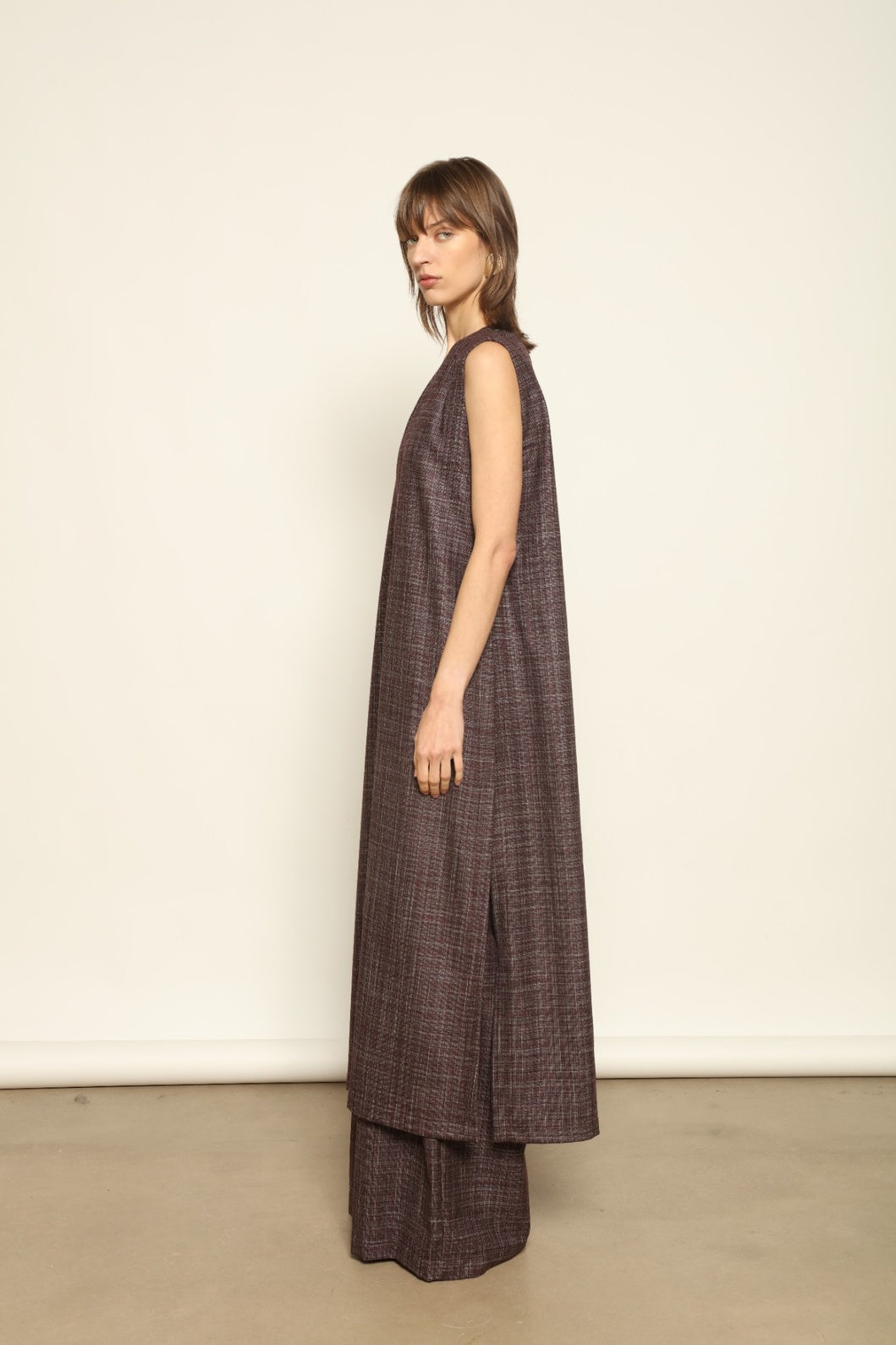 Model is wearing the Athen Burgundy Tunic Dress by House of Woven Stories, made from a wool, silk, and cashmere blend with longline silhouette and deep V-neck.