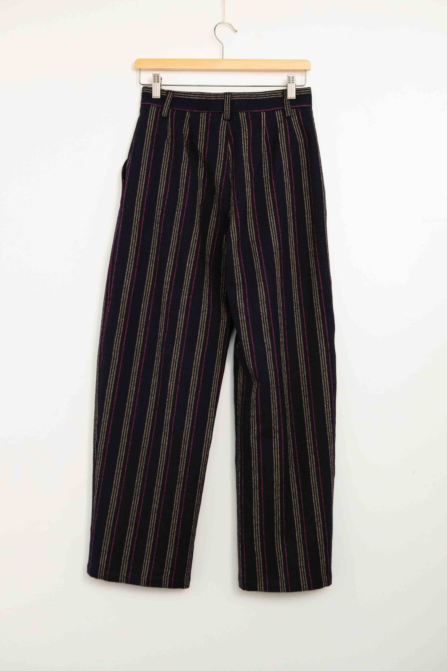 Model is wearing Balia 8.22 navy blue striped trousers made from virgin wool and cotton, tailored fit, Italian craftsmanship, part of House of Woven Stories selection.