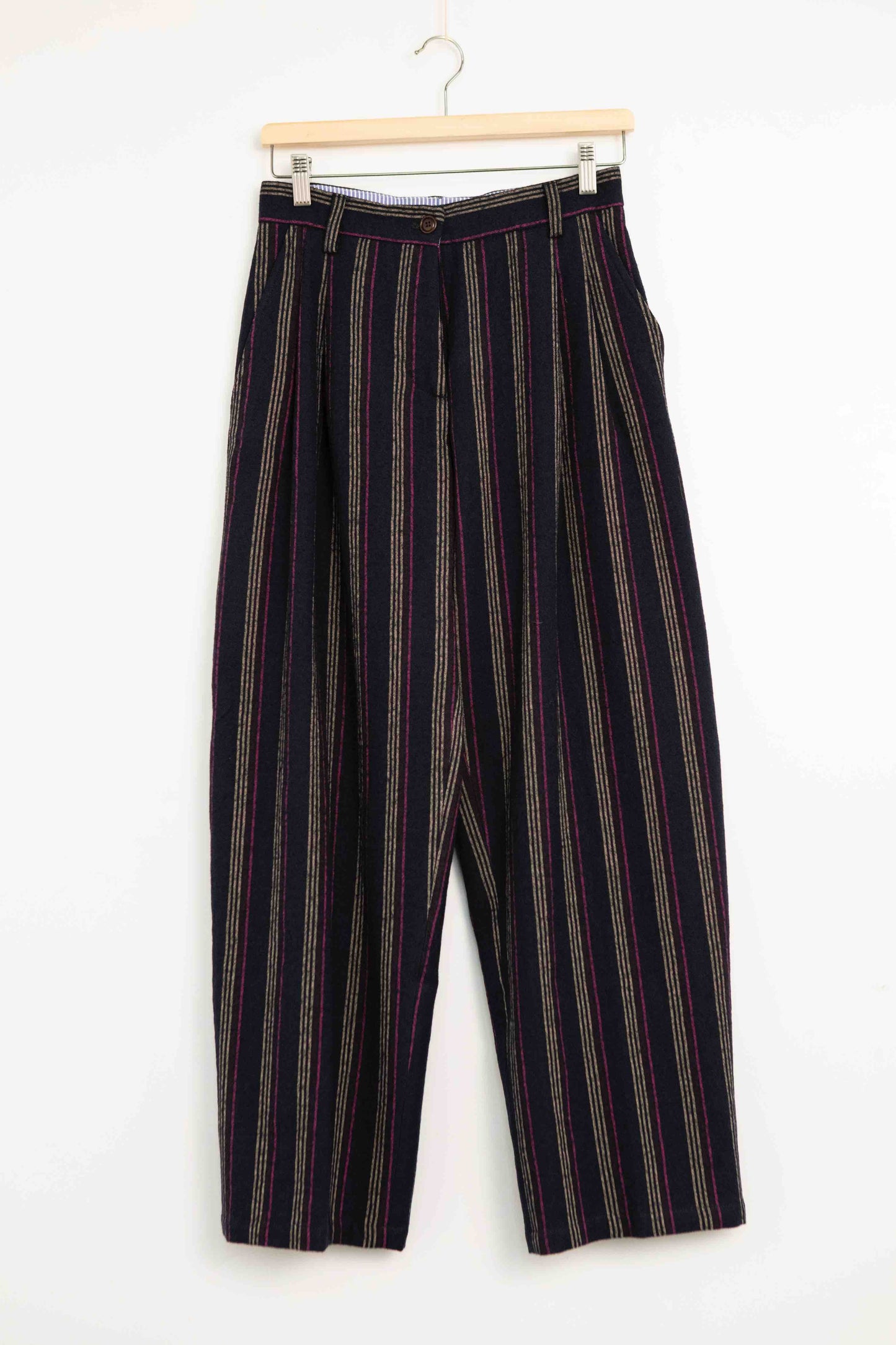 Model is wearing Balia 8.22 navy blue striped trousers made from virgin wool and cotton, tailored fit, Italian craftsmanship, part of House of Woven Stories selection.