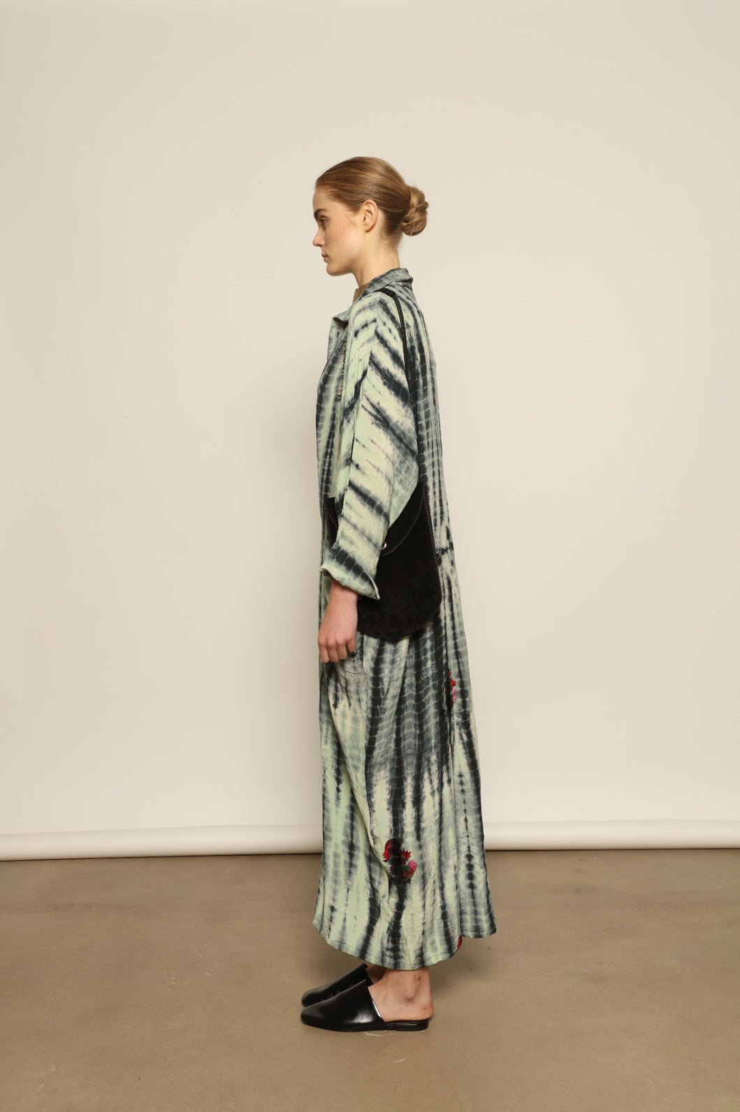 Model is wearing the Barcelona Stone Shade Dress by House of Woven Stories, crafted from 100% pure silk with stone-toned tie-dye and delicate hand-embroidered flowers, featuring a relaxed silhouette and soft collar for artistic, effortless elegance.