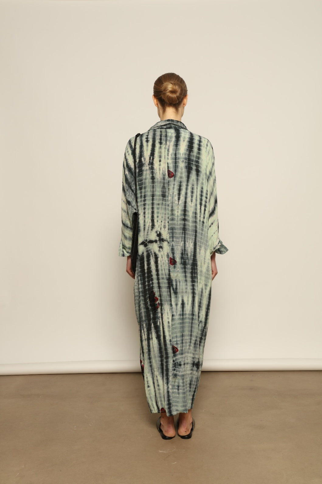 Model is wearing the Barcelona Stone Shade Dress by House of Woven Stories, crafted from 100% pure silk with stone-toned tie-dye and delicate hand-embroidered flowers, featuring a relaxed silhouette and soft collar for artistic, effortless elegance.