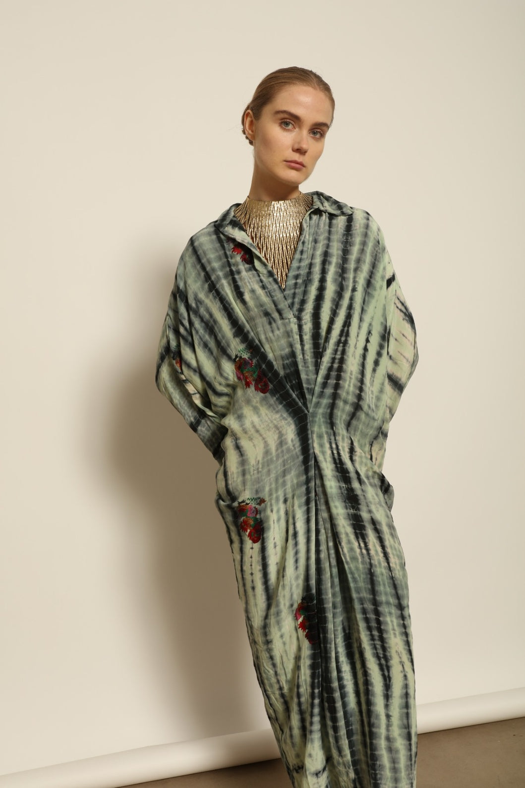 Model is wearing the Barcelona Stone Shade Dress by House of Woven Stories, crafted from 100% pure silk with stone-toned tie-dye and delicate hand-embroidered flowers, featuring a relaxed silhouette and soft collar for artistic, effortless elegance.