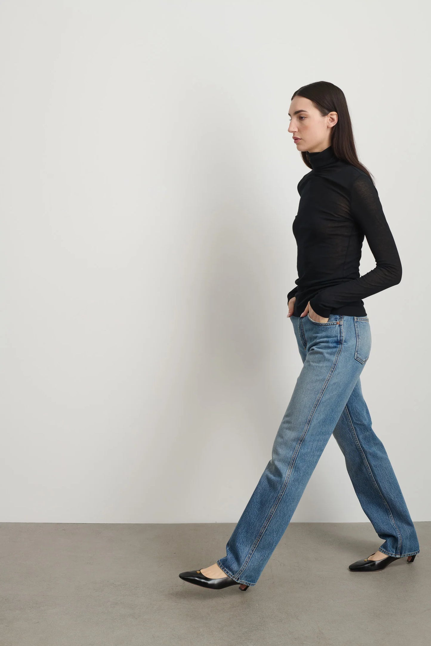 Model is wearing Jana Cotton Turtleneck in Black by B Sides in Japanese-milled black rib crepe with long sleeves, second-skin fit and raw finishing details, available at House of Nomad Stories