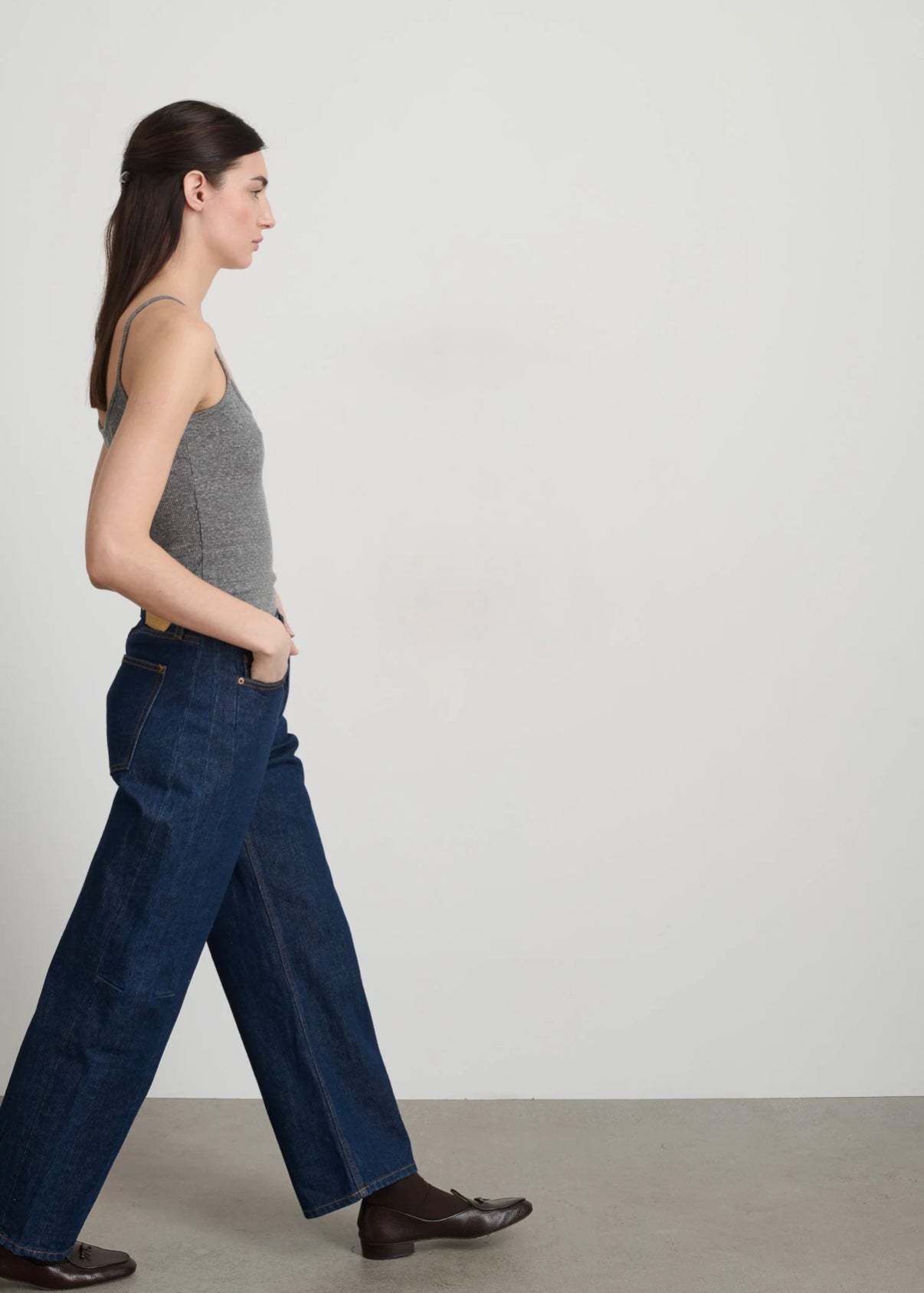 Model is wearing B Sides Lasso Jeans in double-faced Japanese denim, natural waist, kinked leg, cropped length, roped hem, with signature outseam detailing, part of House of Woven Stories curated collection.